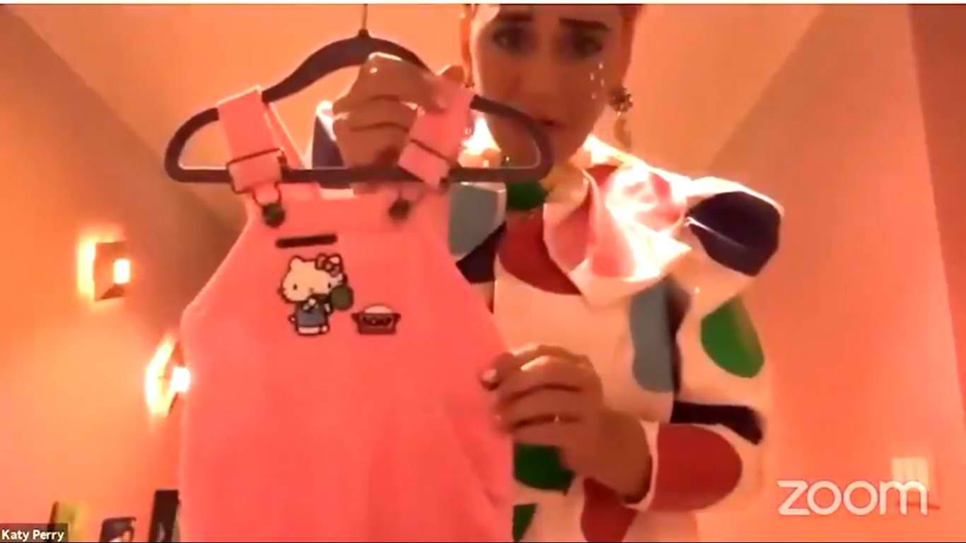 Katy Perry showing off a onesie, one of the many baby clothes she prepared in her daughter's room. | Photo: YouTube/ Katy Perry