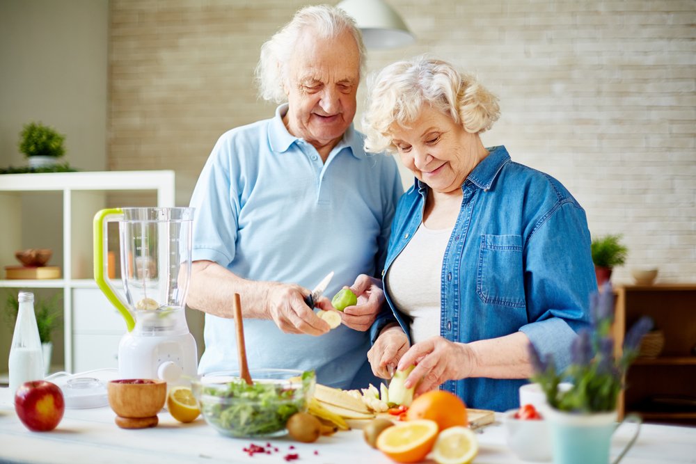 Modernes älteres Paar, das frische Früchte für Smoothie vorbereitet | Quelle: Shutterstock