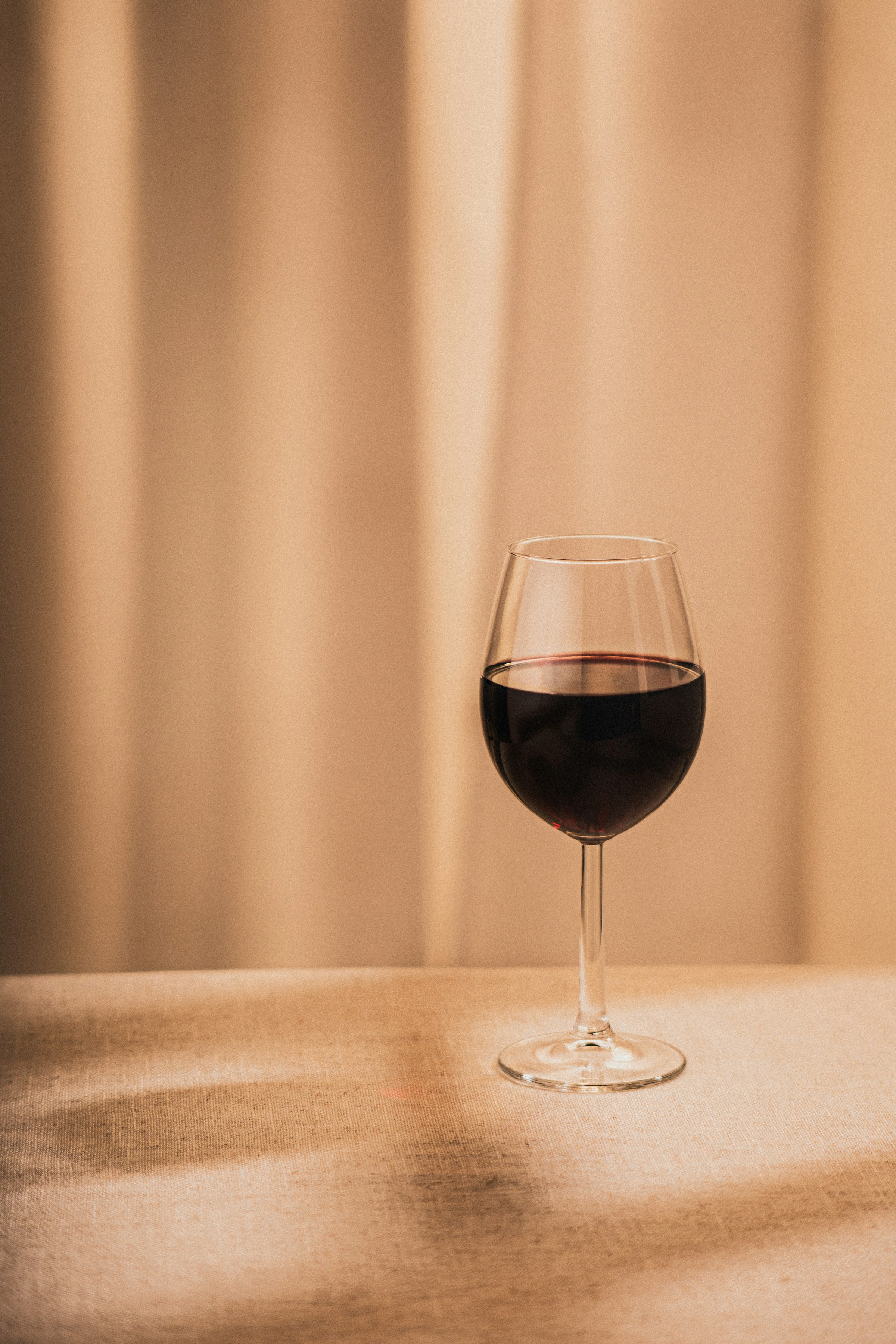 A glass of wine on a table | Source: Unsplash