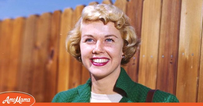 Doris Day pictured wearing a green coat paired with a white dress, and a brown side bag in 1945. / Source: Getty Images
