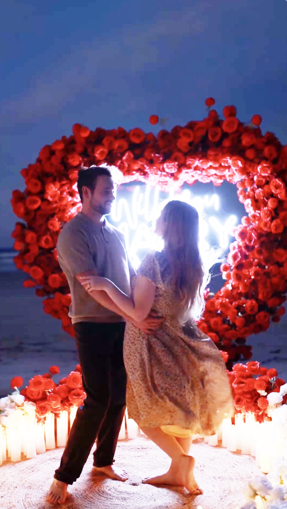 Jason Duggar and Maddie Grace looking at each other while standing in front of the romantic neon backdrop, as seen in a video dated August 30, 2024 | Source: Instagram/kaylajohnsonphoto_