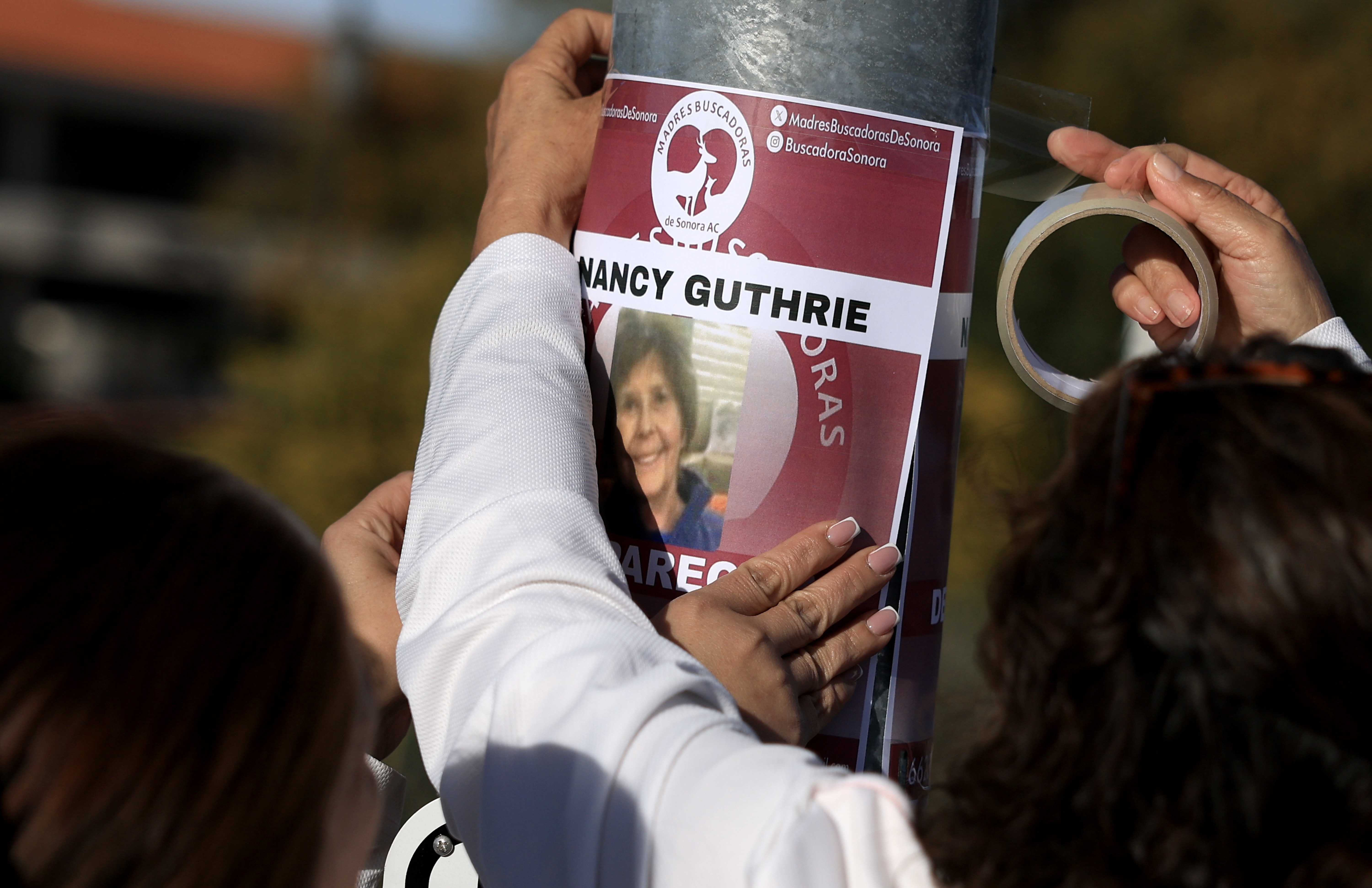 Volunteers post a missing flyer for Nancy Guthrie in Tucson, Arizona, on February 24, 2026, as search efforts continue | Source: Getty Images