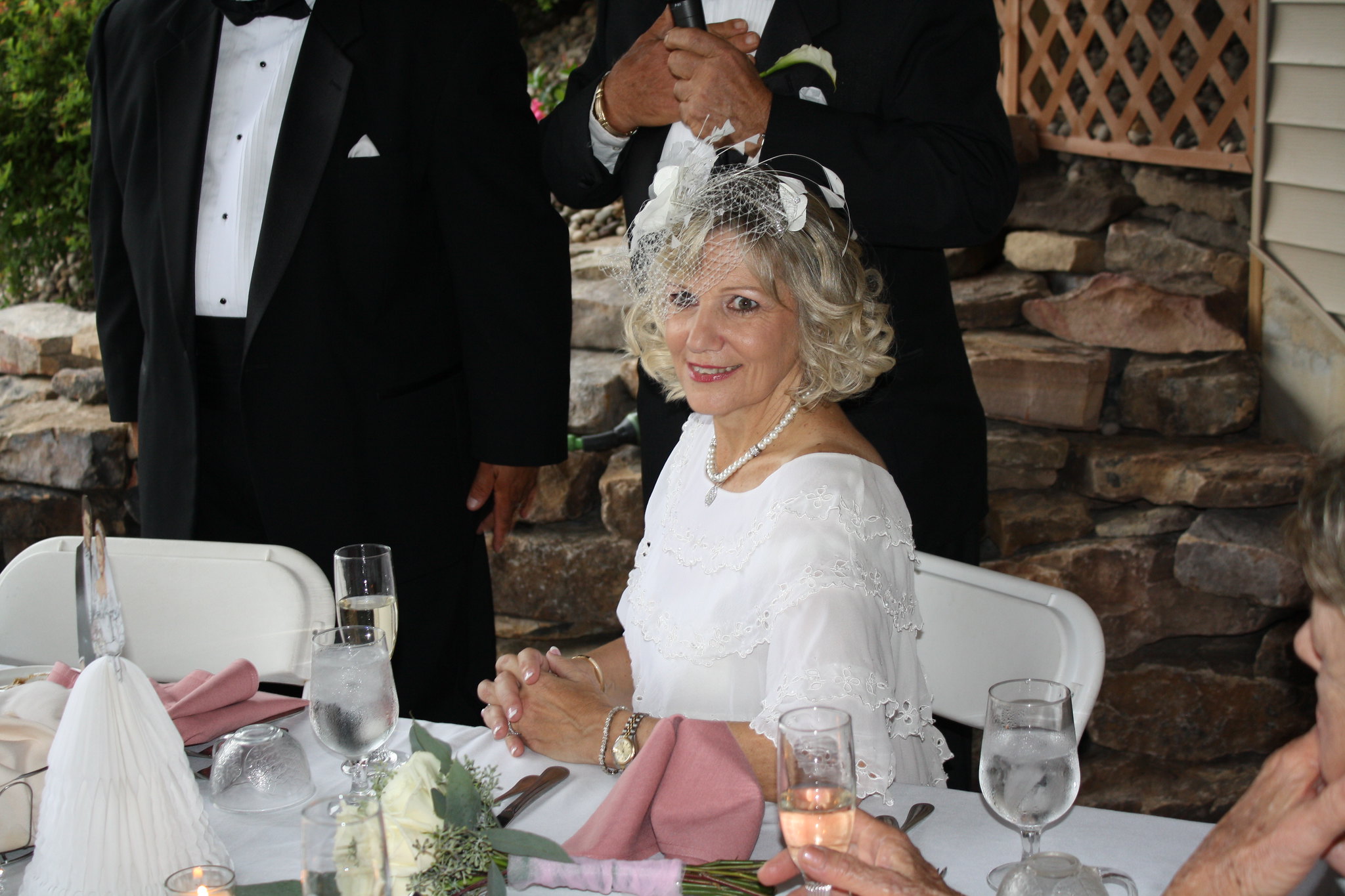 An older woman dressed in all white with a white fascinator | Source: Brett Levy on Flickr