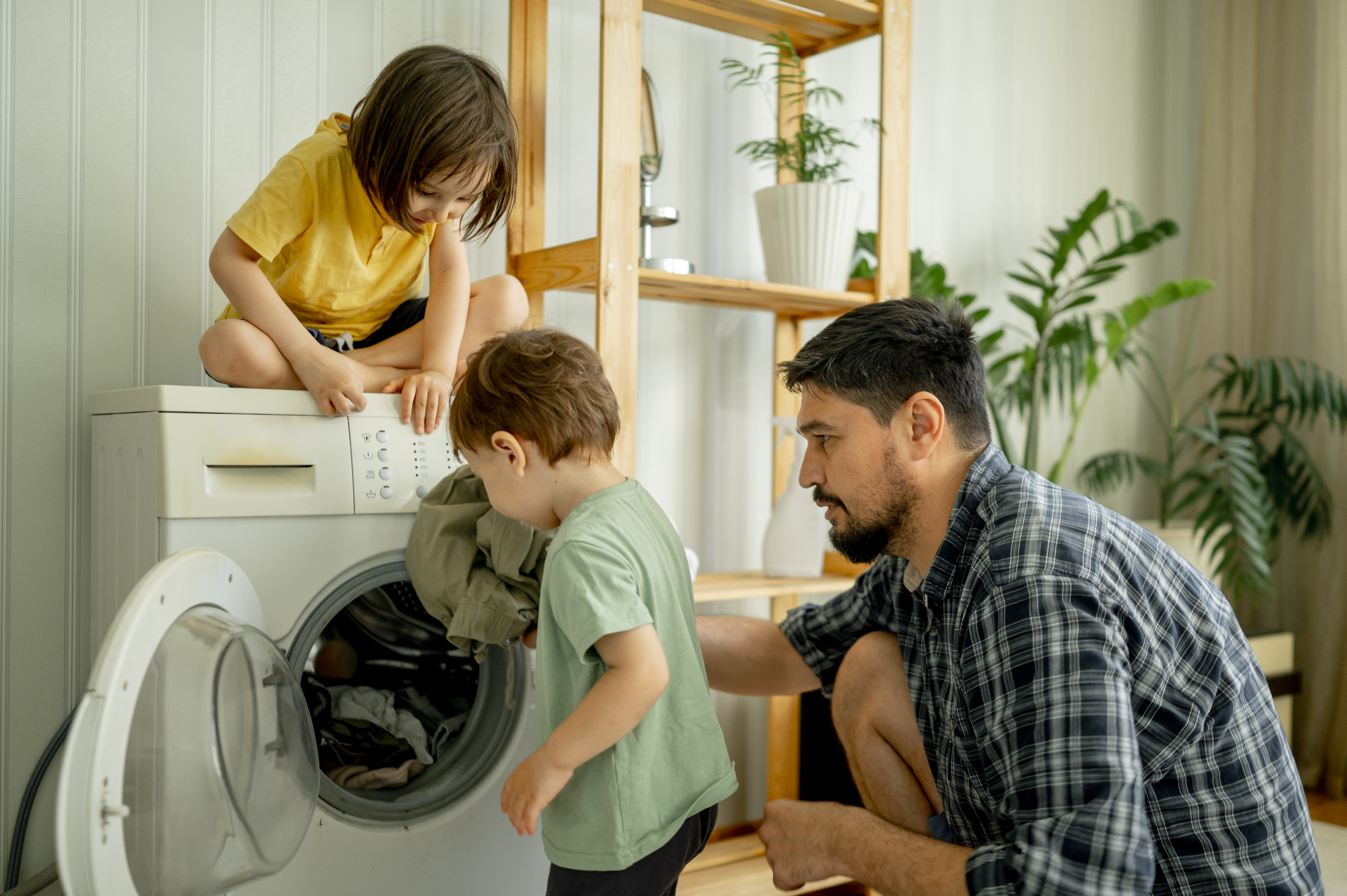 A man and his children doing laundry | Source: Getty Images