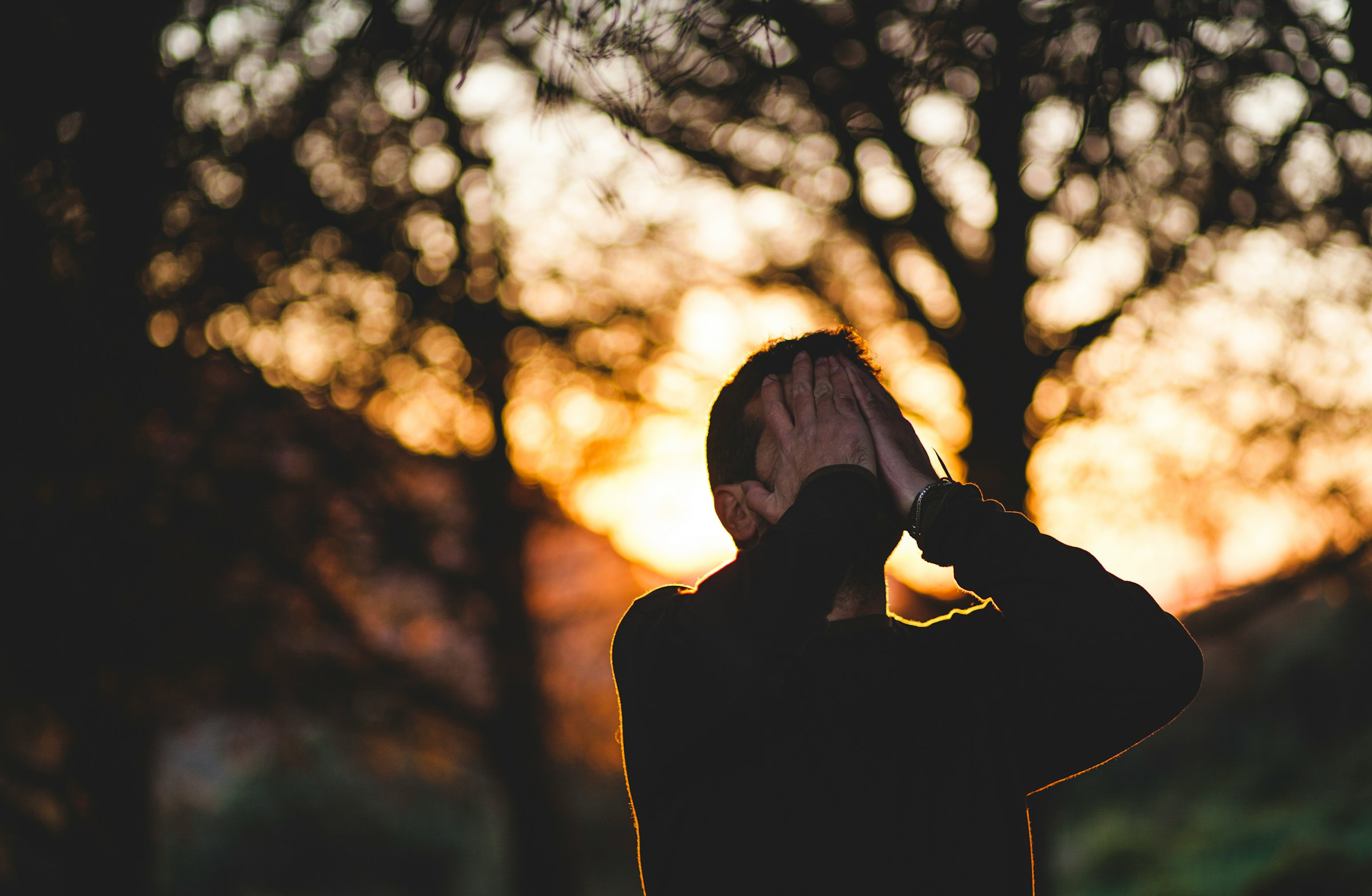 A distraught man covering his face with his hands | Source: Unsplash