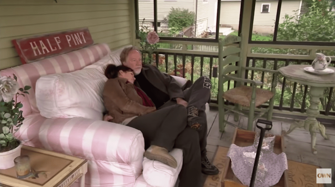 Melissa Gilbert and her husband Tim Busfield sitting on the porch of their Michigan home. | Source: YouTube/OWN