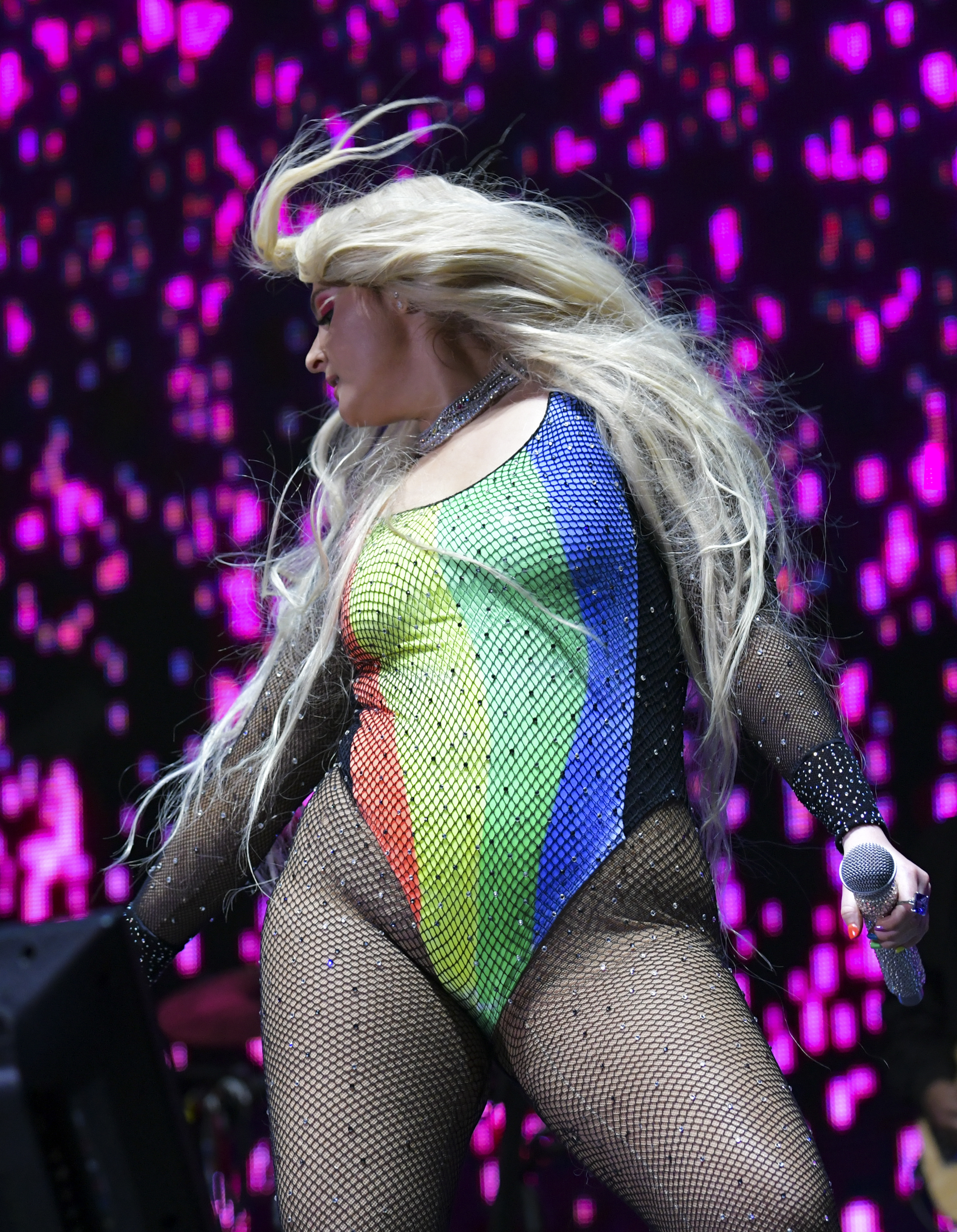 Meghan Trainor electrifies the stage at LA Pride in West Hollywood, rocking a rainbow bodysuit layered with sparkling fishnet. With her hair flying mid-performance and microphone in hand, she radiates fierce energy and unapologetic pride.