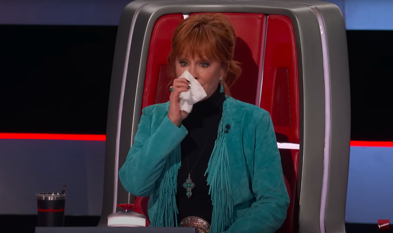 Reba McEntire wiping away tears from her eyes. | Source: YouTube/The Voice