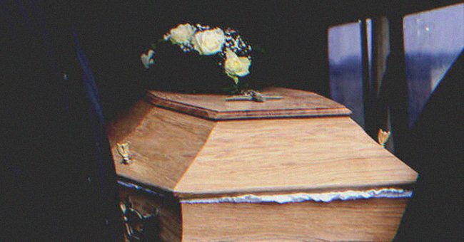 A coffin with some flowers on top of it | Source: Shutterstock