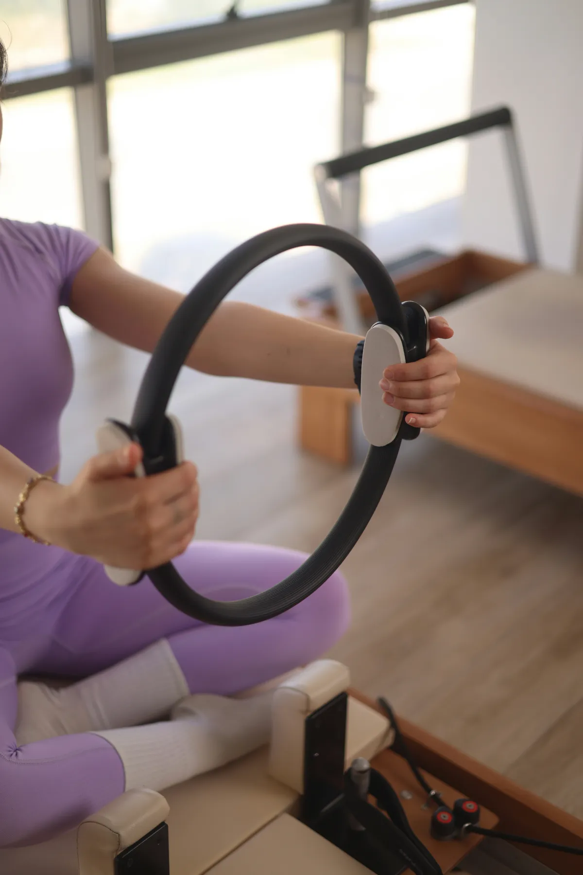 A woman holds on to a Pilates ring | Source: Unsplash