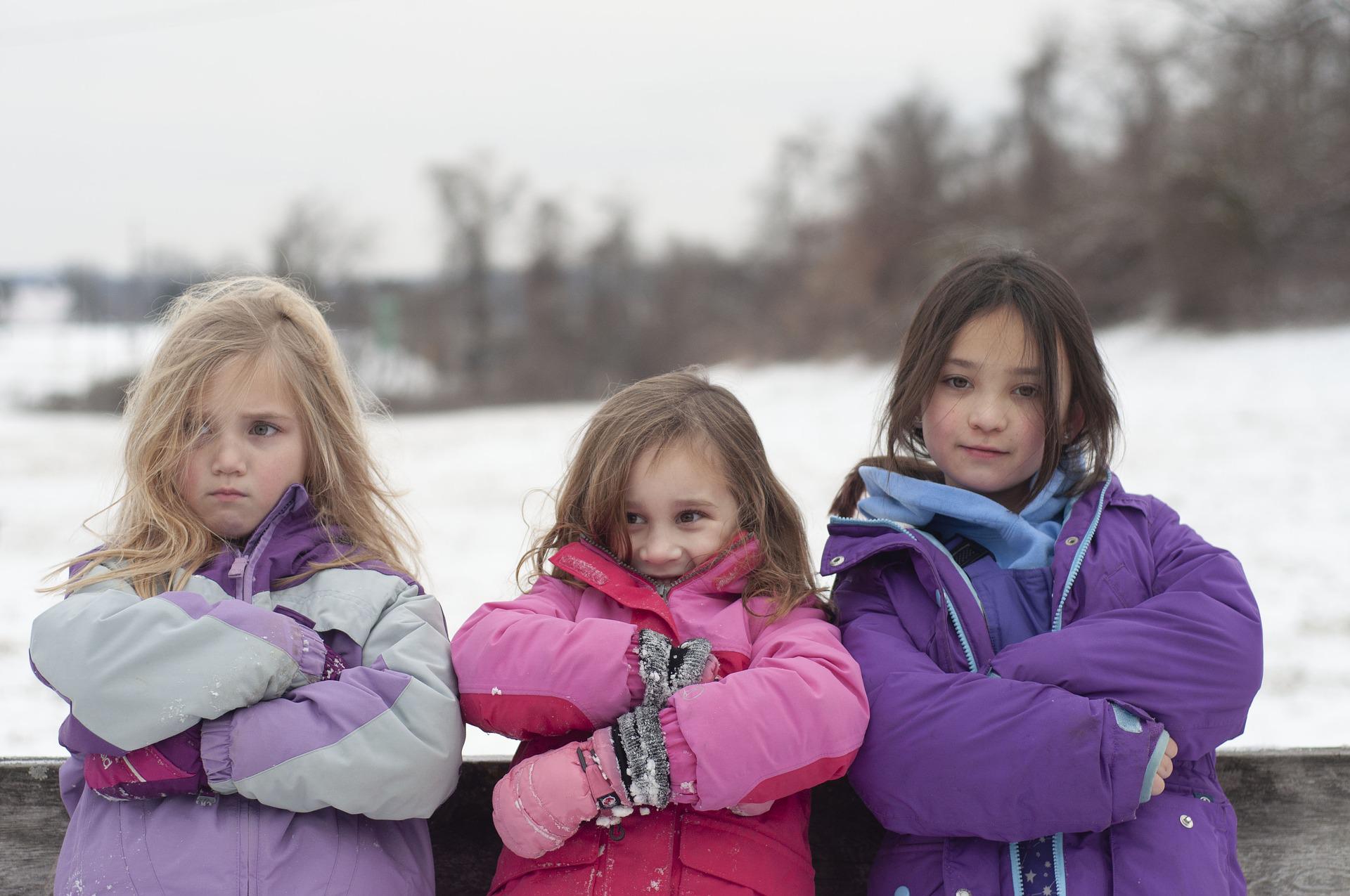 Tres niñas con abrigos de invierno. | Foto: Pixabay