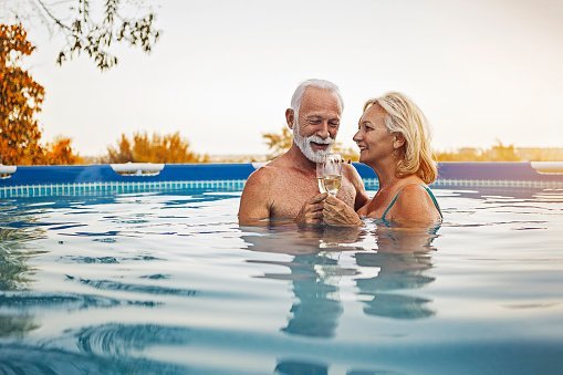 Photo of Senior couple enjoying summertime in a swimming pool | Photo: Getty Images