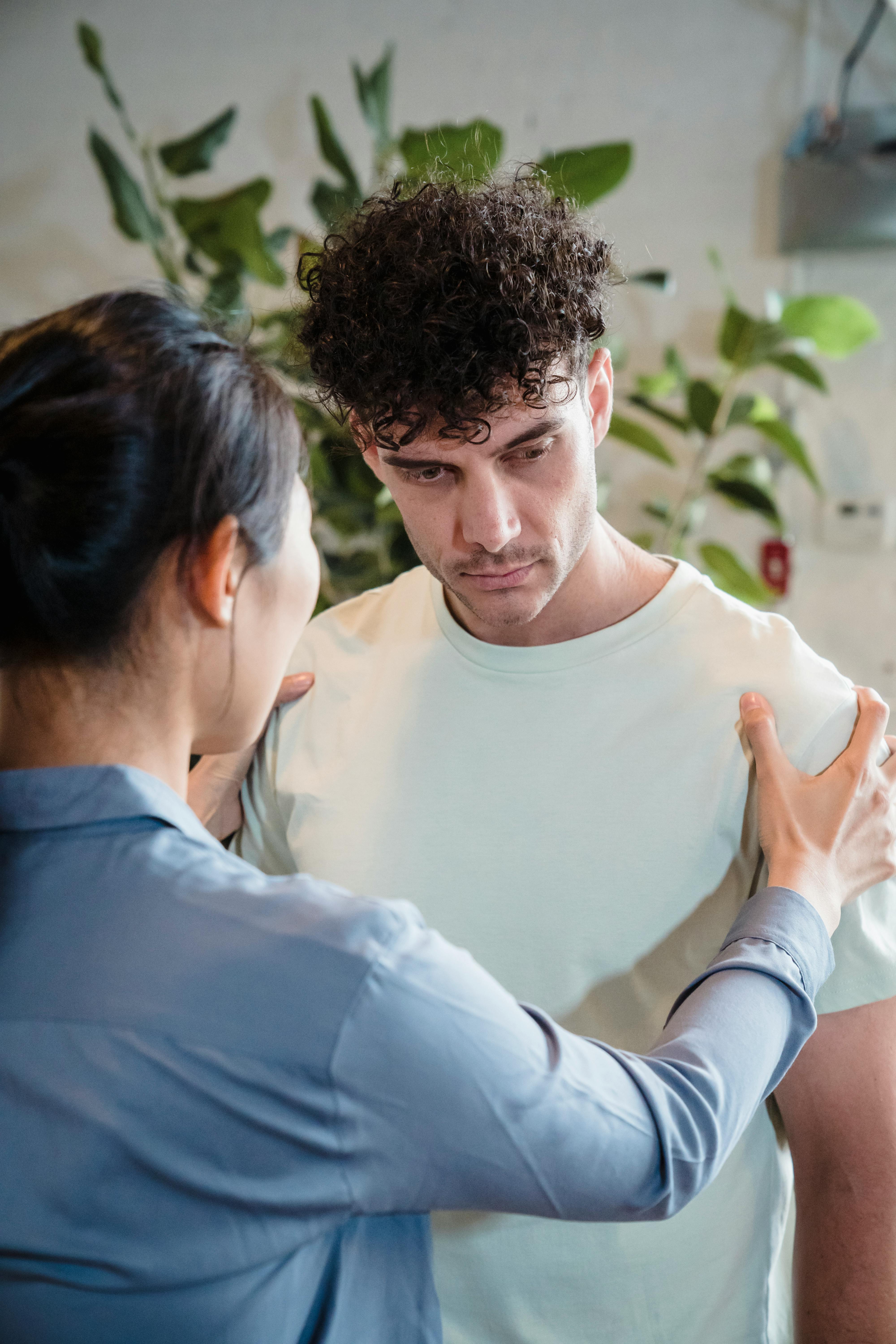 A woman holding a man's shoulders | Source: Pexels