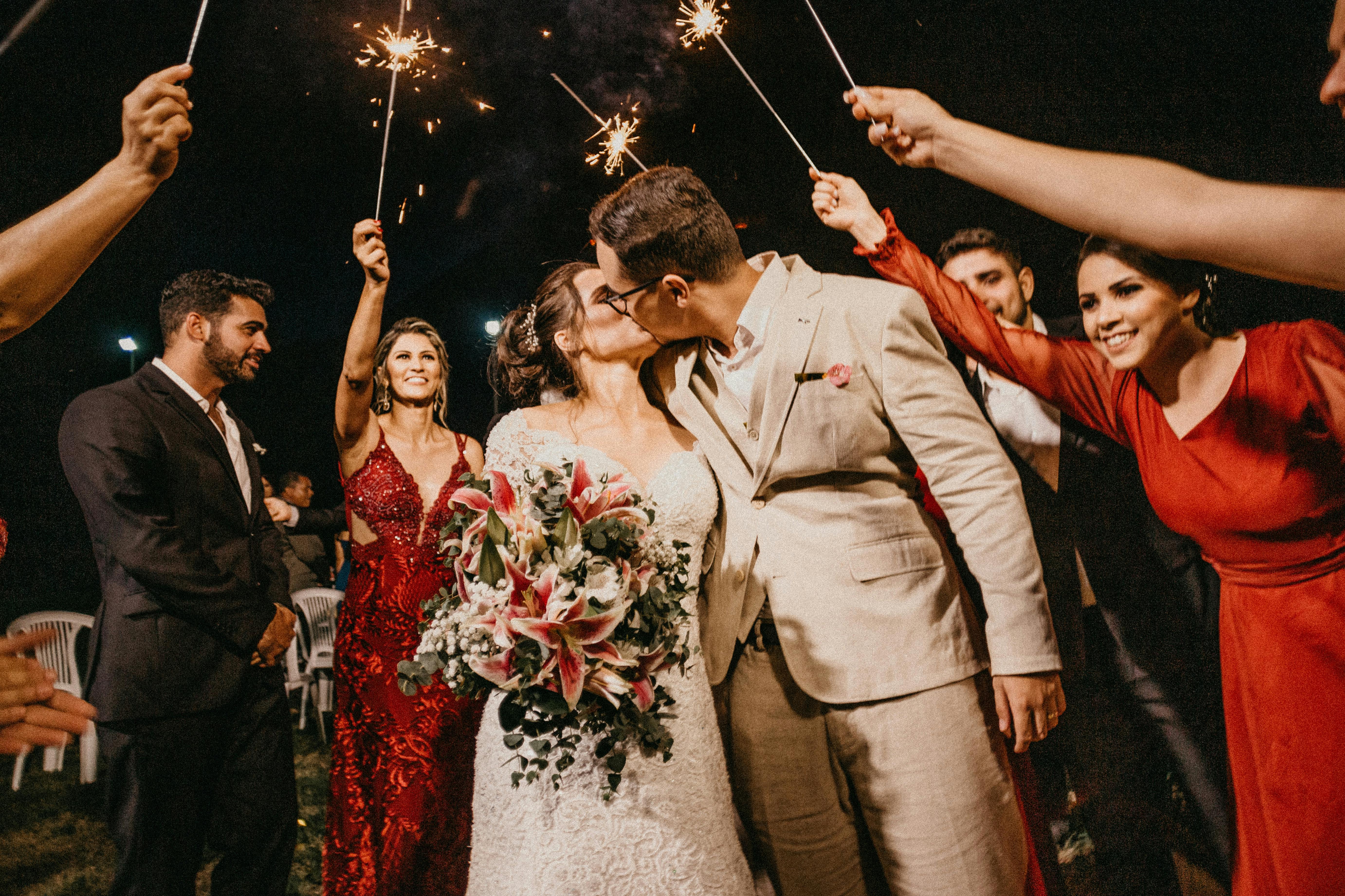 A couple kissing while being celebrated by family members | Source: Pexels