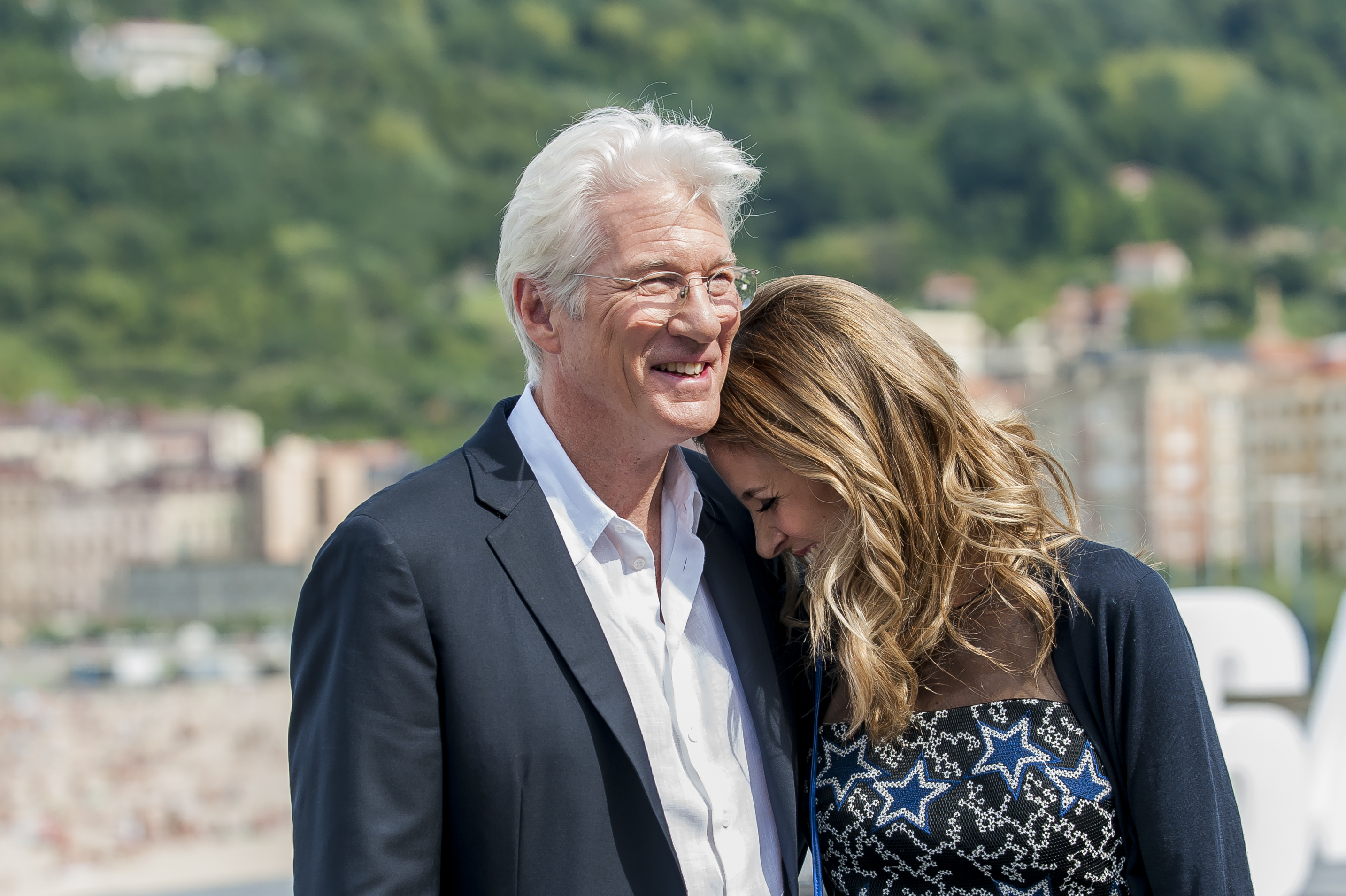 At the 64th San Sebastián Film Festival on September 24, 2016, Richard Gere stood in a dark blazer beside Alejandra Silva, who wore a sleeveless cream blouse with tousled waves, both posing calmly before a neutral backdrop at the "Time Out of Mind" photocall.