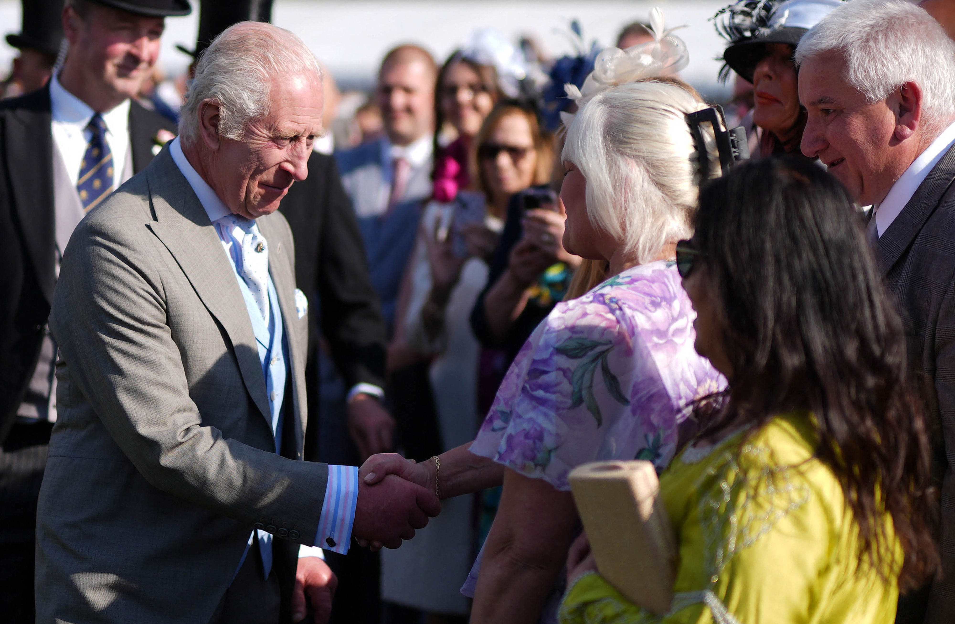 King Charles III shakes hands with a guest during a Royal Garden Party at Buckingham Palace, central London, on May 8, 2024. | Source: Getty Images