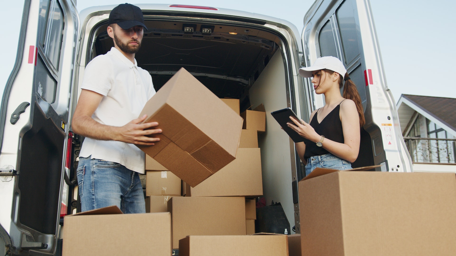 Two people loading boxes into a vehicle | Source: Pexels