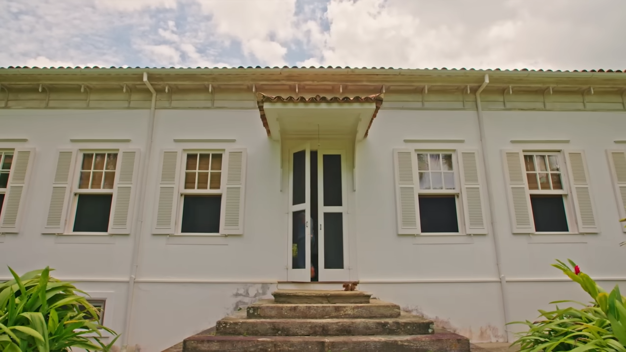 The entrance of the main 19th-century Portuguese colonial-style farmhouse, showing classic stone steps and white-panel shutters. | Source: YouTube/@Archdigest