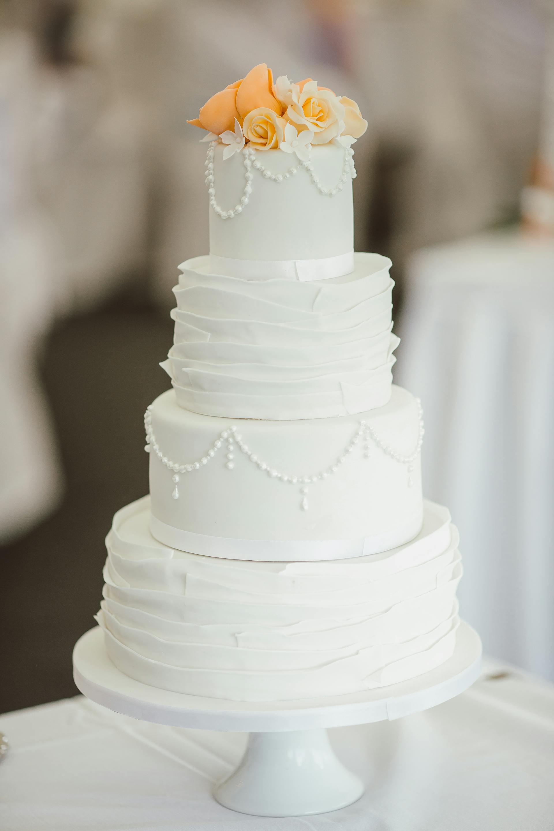 A four-tier cake on a cake stand | Source: Pexels