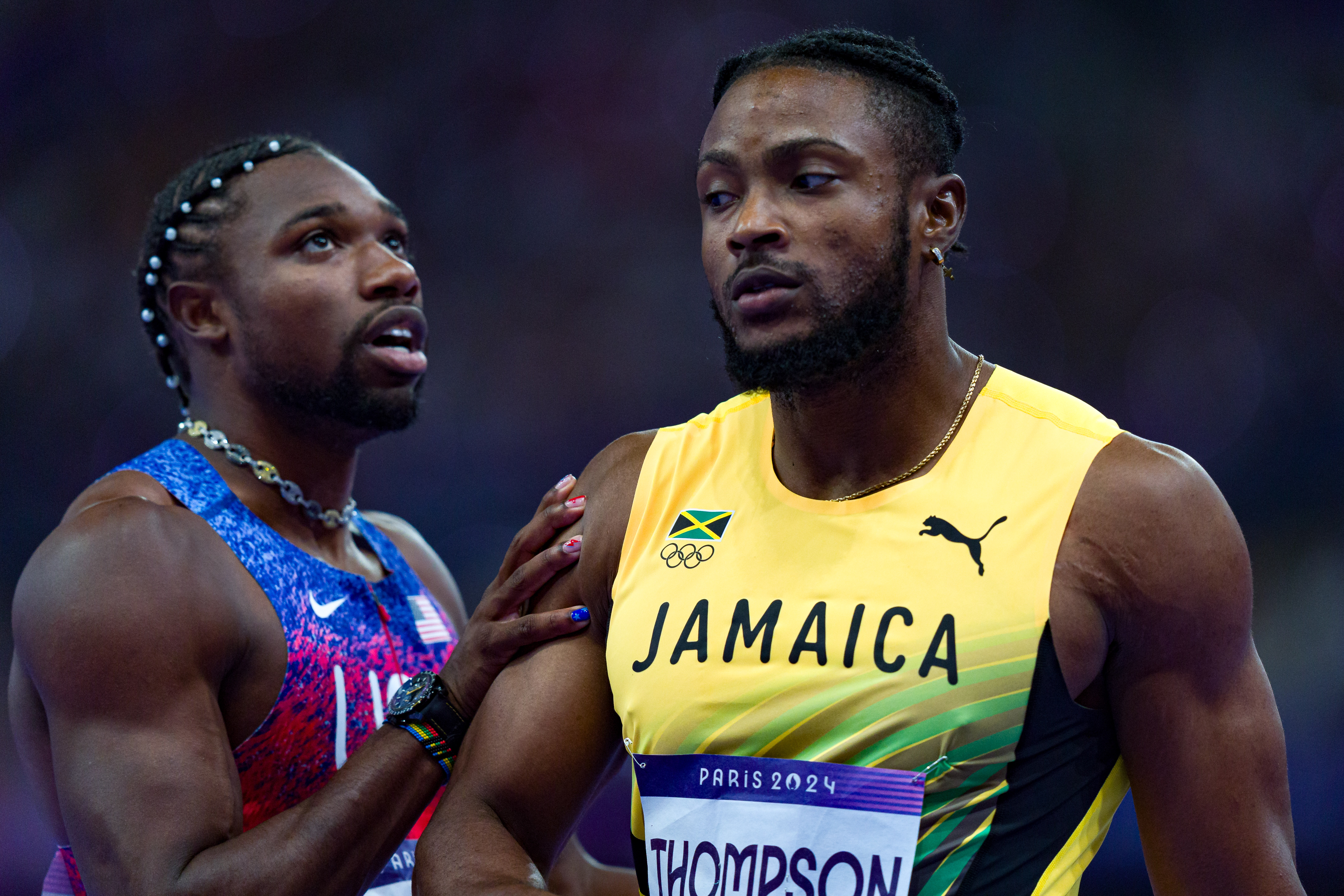 Noah Lyles and Kishane Thompson react as they wait for the results of the competition during the men's 100m final of the athletics event at the Paris 2024 Olympic Games in Saint-Denis, Paris, on August 4, 2024. | Source: Getty Images