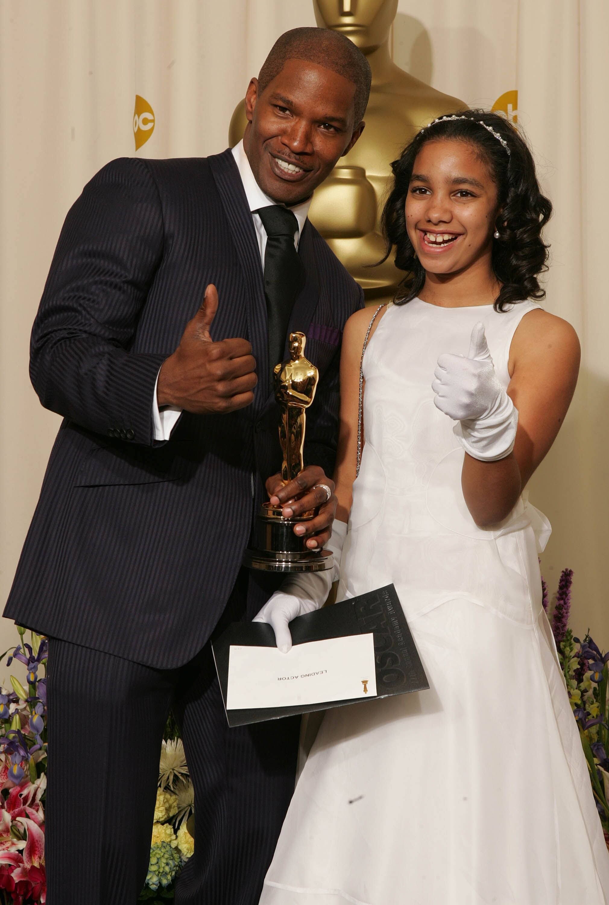 Jamie Foxx poses with his "Best Actor in a Leading Role" award for "Ray" with his daughter Corrine Marie Foxx backstage during the 77th Annual Academy Awards in 2005 | Getty Images