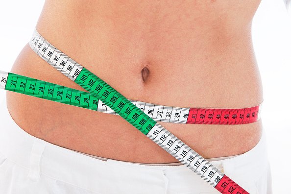 Femme mesurant sa taille.|Photo : Getty Images