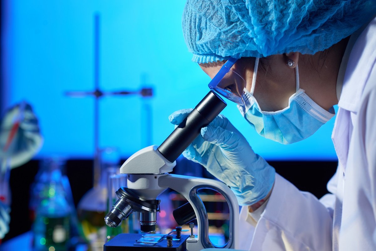 Profesional con atuendo de protección estudia una muestra en microscopio. | Foto: Freepik Profesional con atuendo de protección estudia una muestra en microscopio. | Foto: Freepik