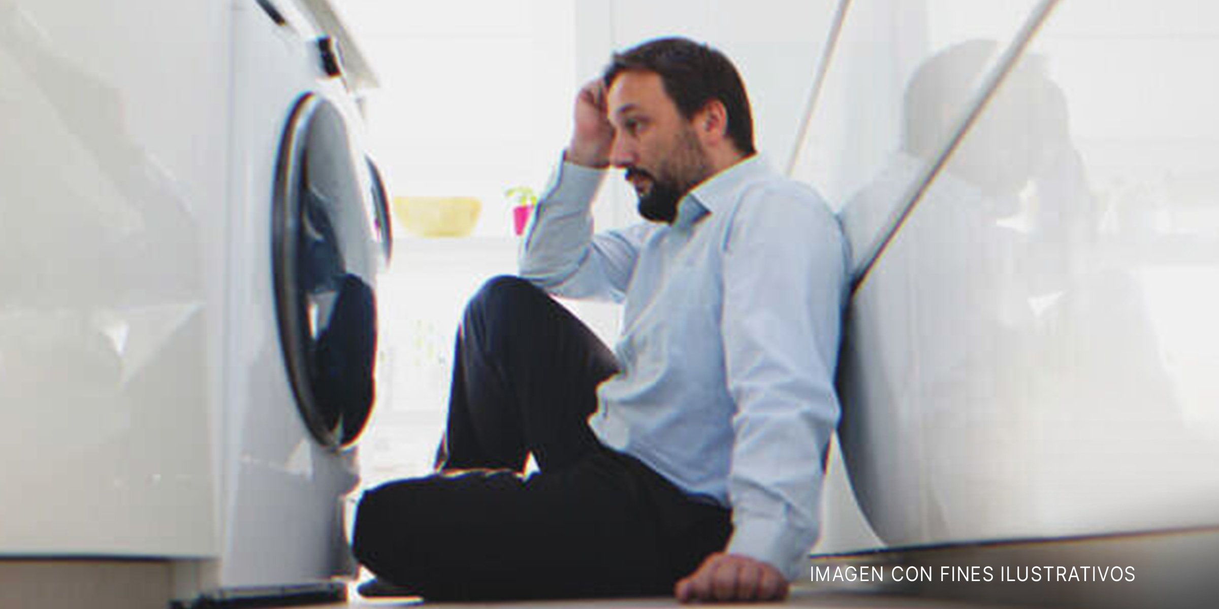 Hombre sentado frente a la lavadora | Foto: Shutterstock