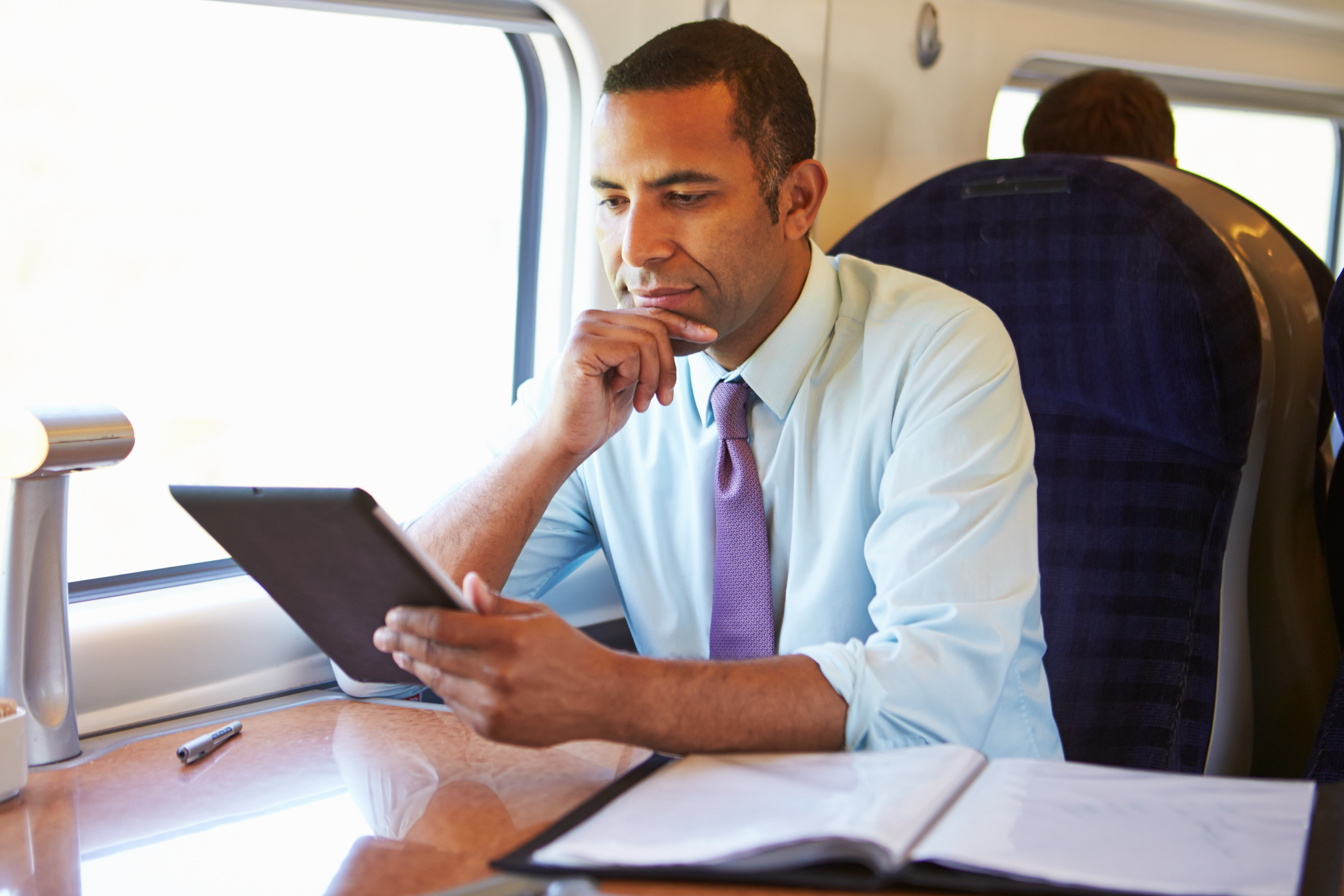 A man sitting in a window seat on a train | Source: Shutterstock