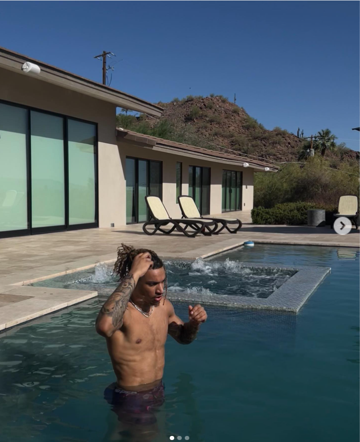 Brandon Clarke stands in a swimming pool outside a modern hillside home while adjusting his hair. | Source: Instagram/brandon_clarke23