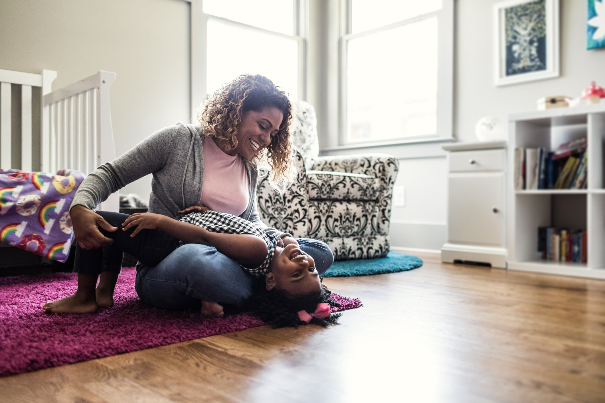 An image of a mother and her daughter playing on the bedroom floor. | Photo: Getty Images