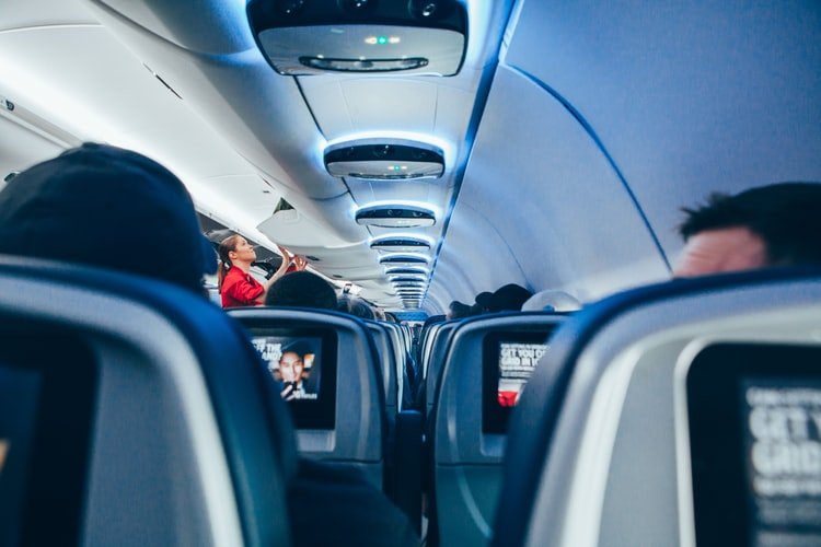 A photo of passengers in their seats on a flight. | Photo: Unspalsh.