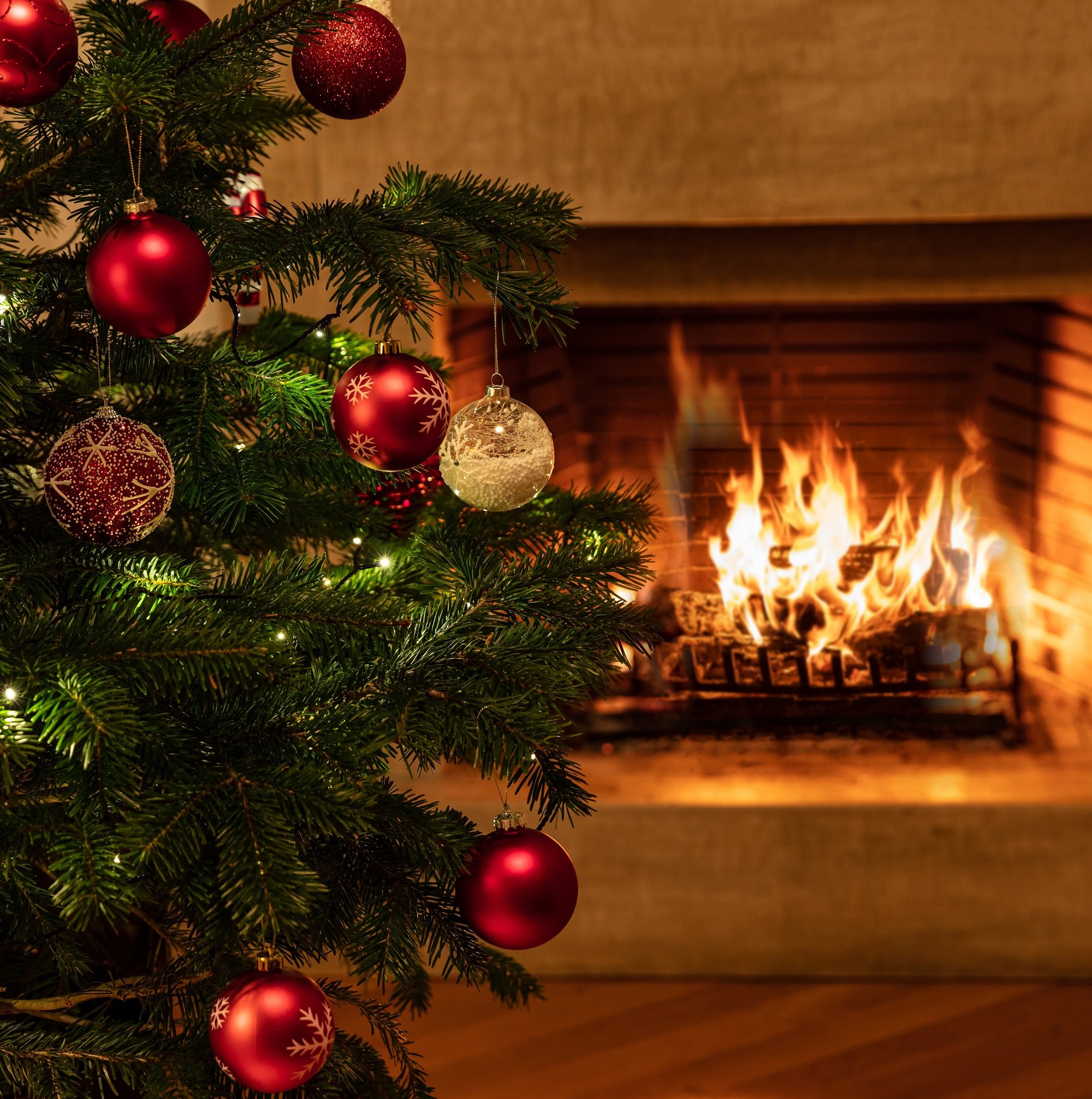 Árbol de Navidad decorado frente a chimenea. | Foto: Shutterstock