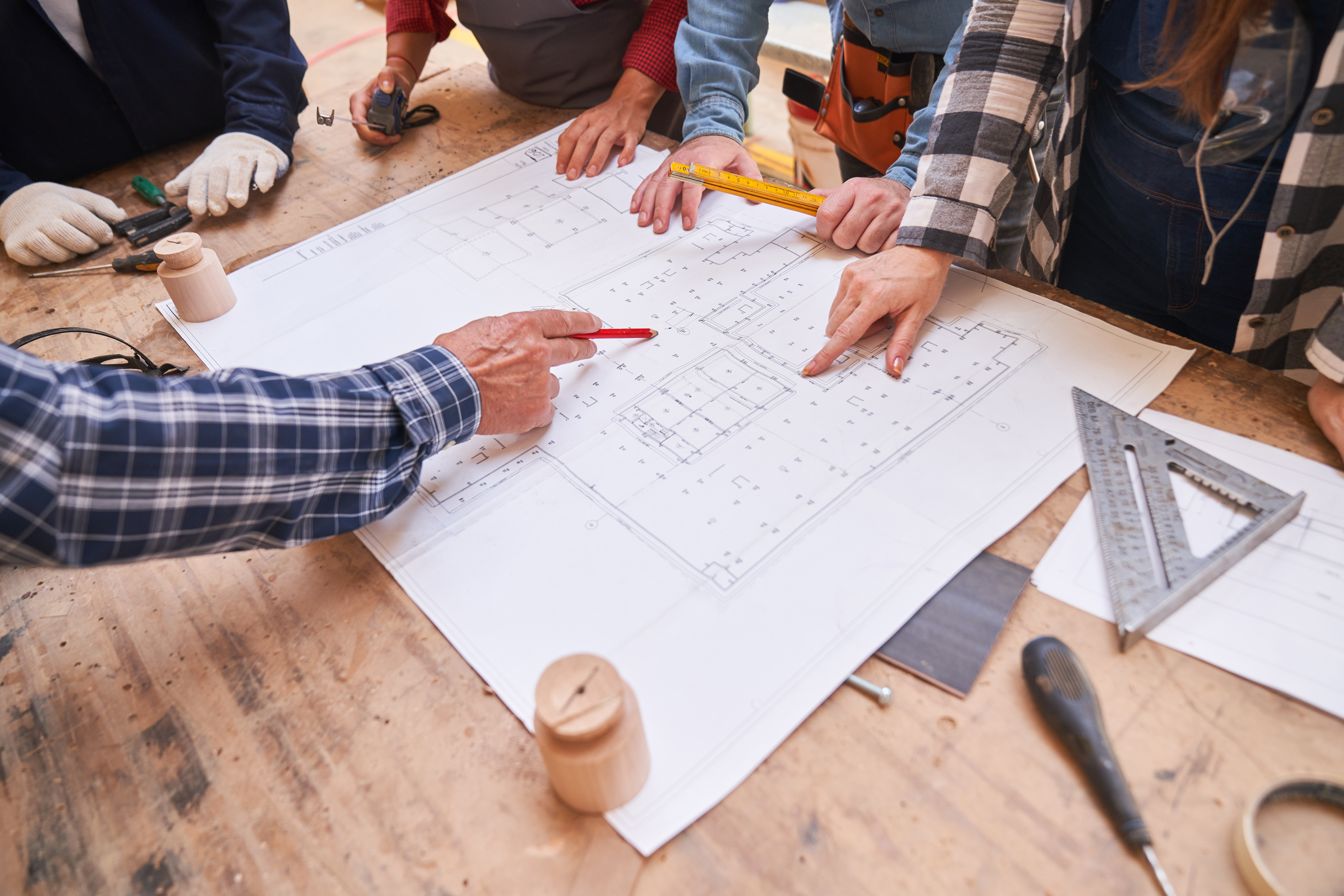 Men looking at construction plan | Shutterstock