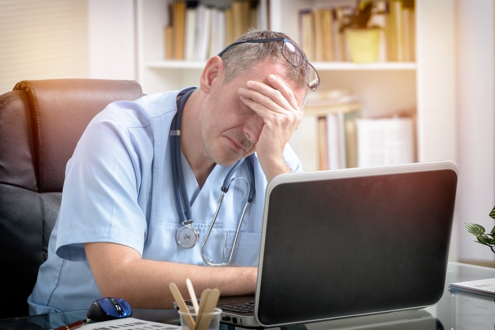 Médico preocupado frente a una computadora. | Foto: Shutterstock