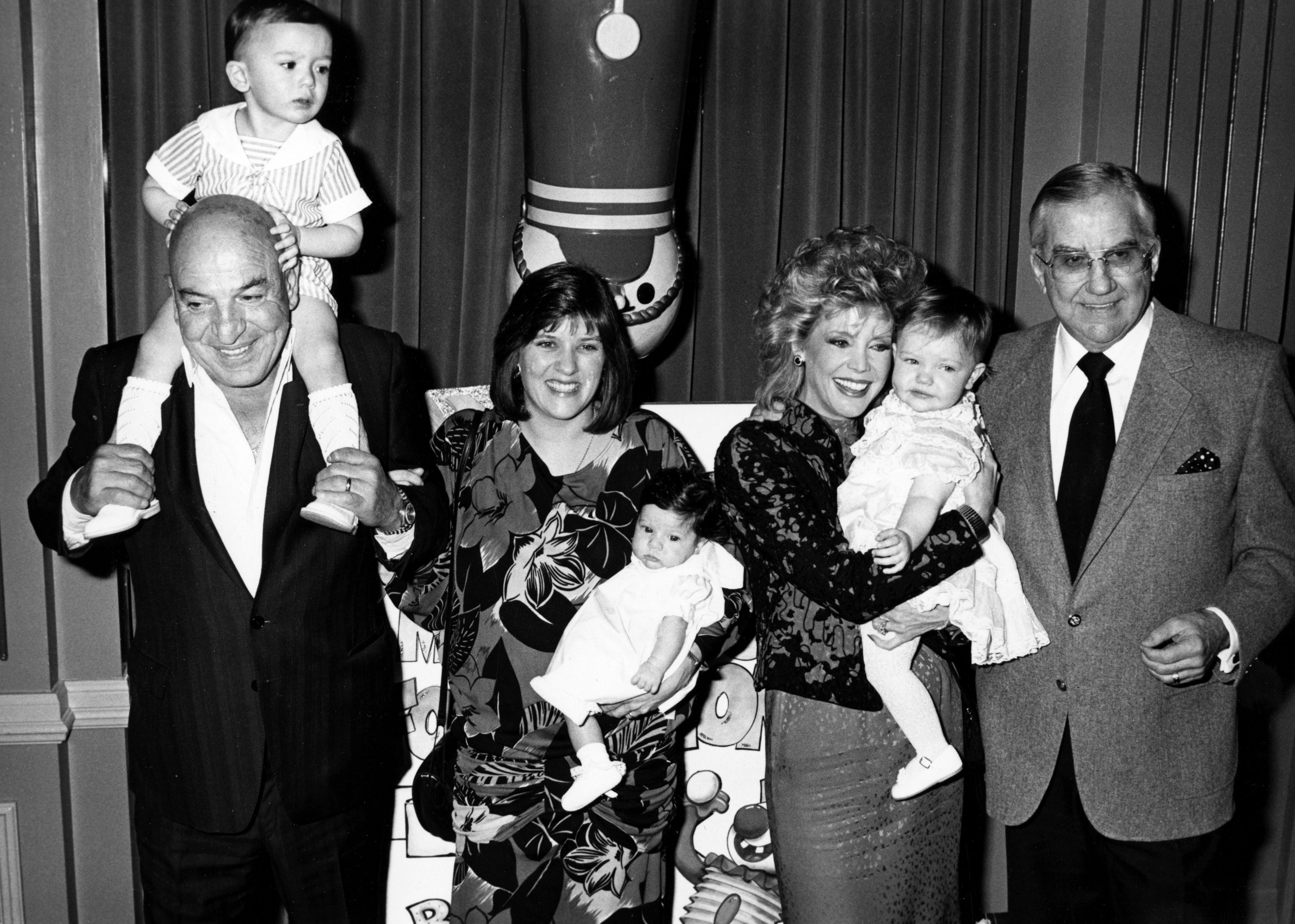 Telly Savalas, wife Julie Hovland, son Christian and daughter Ariana Savalas, Ed McMahon, wife Victoria McMahon and daughter Katherine McMahon at Young Musicians Foundation Celebrity Mother-Daughter Fashion Show on March 26, 1987 | Photo: Getty Images
