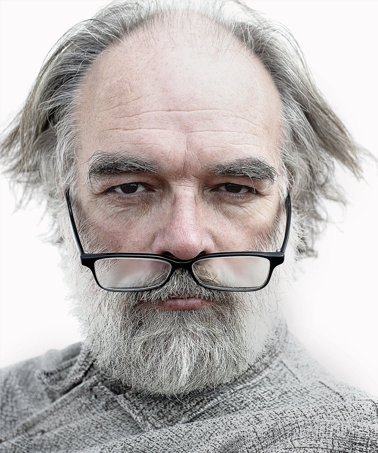 Rostro de un hombre canoso con lentes y barba. | Foto: Pexels