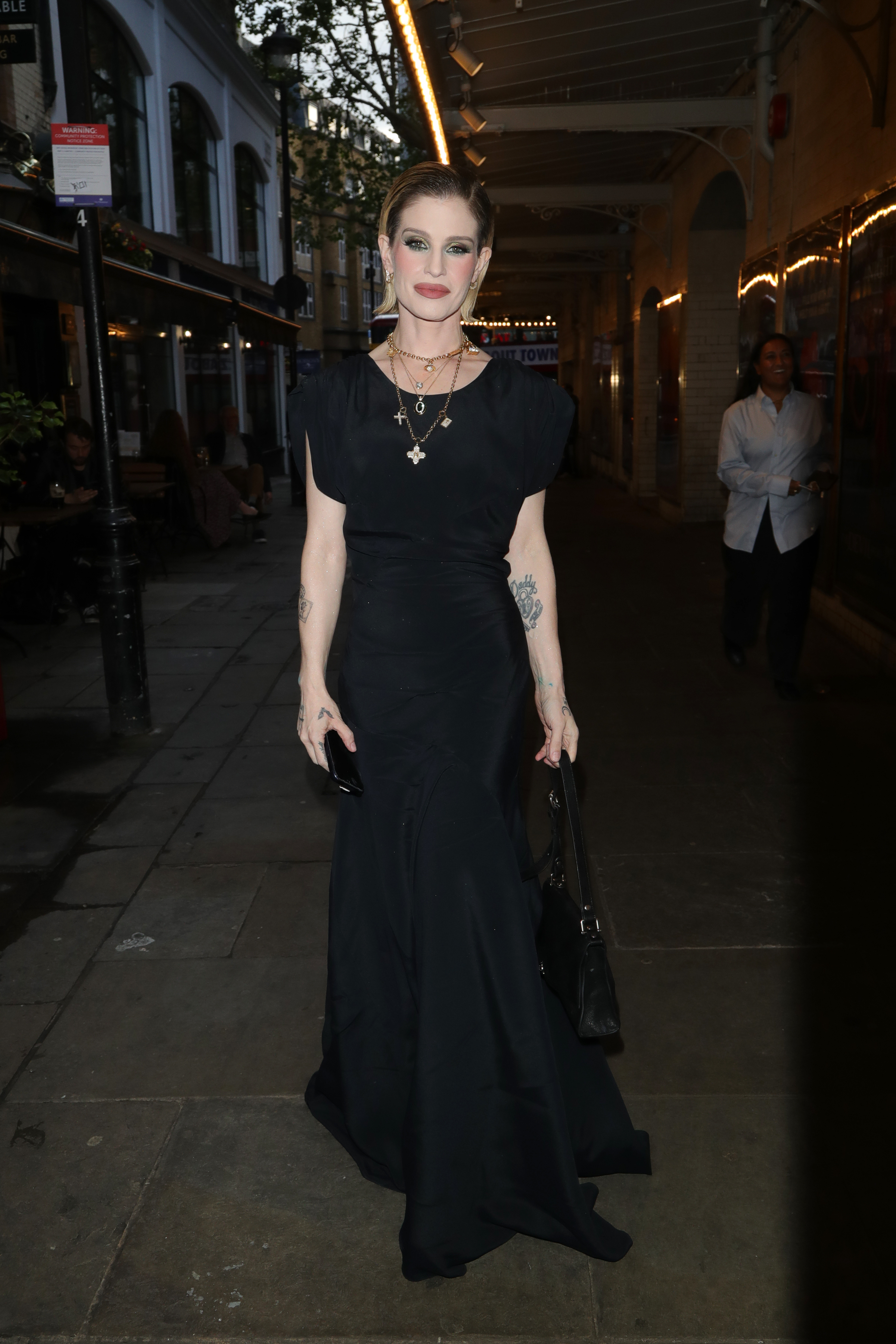 Kelly Osbourne makes a memorable entrance at the Vivienne Westwood x J. Sheekey Terrace launch this June, effortlessly blending sophistication with attitude. The floor-length black gown, dramatic jewelry, and polished styling showcase a look that immediately captured attention.