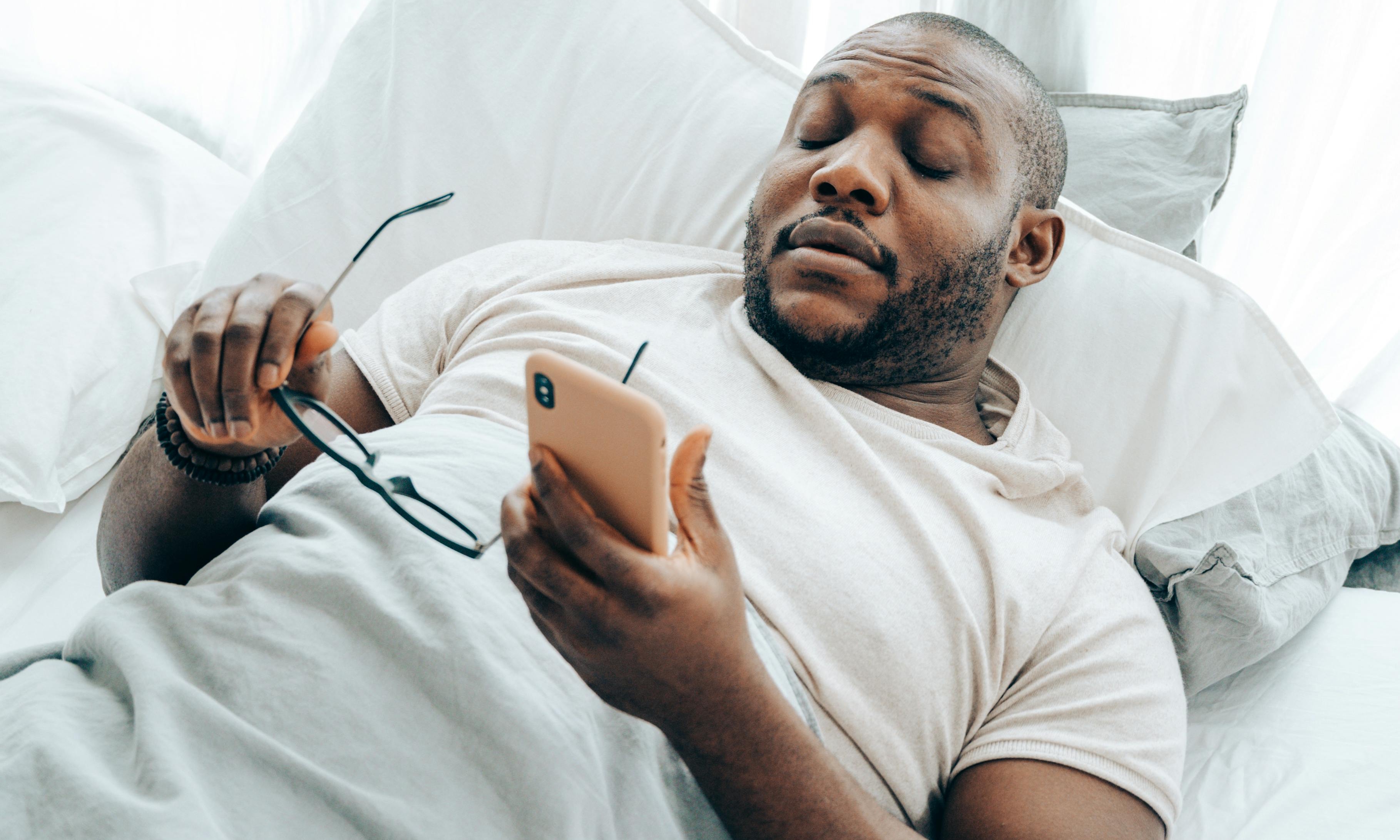 A tired-looking man holding a cell phone | Source: Pexels
