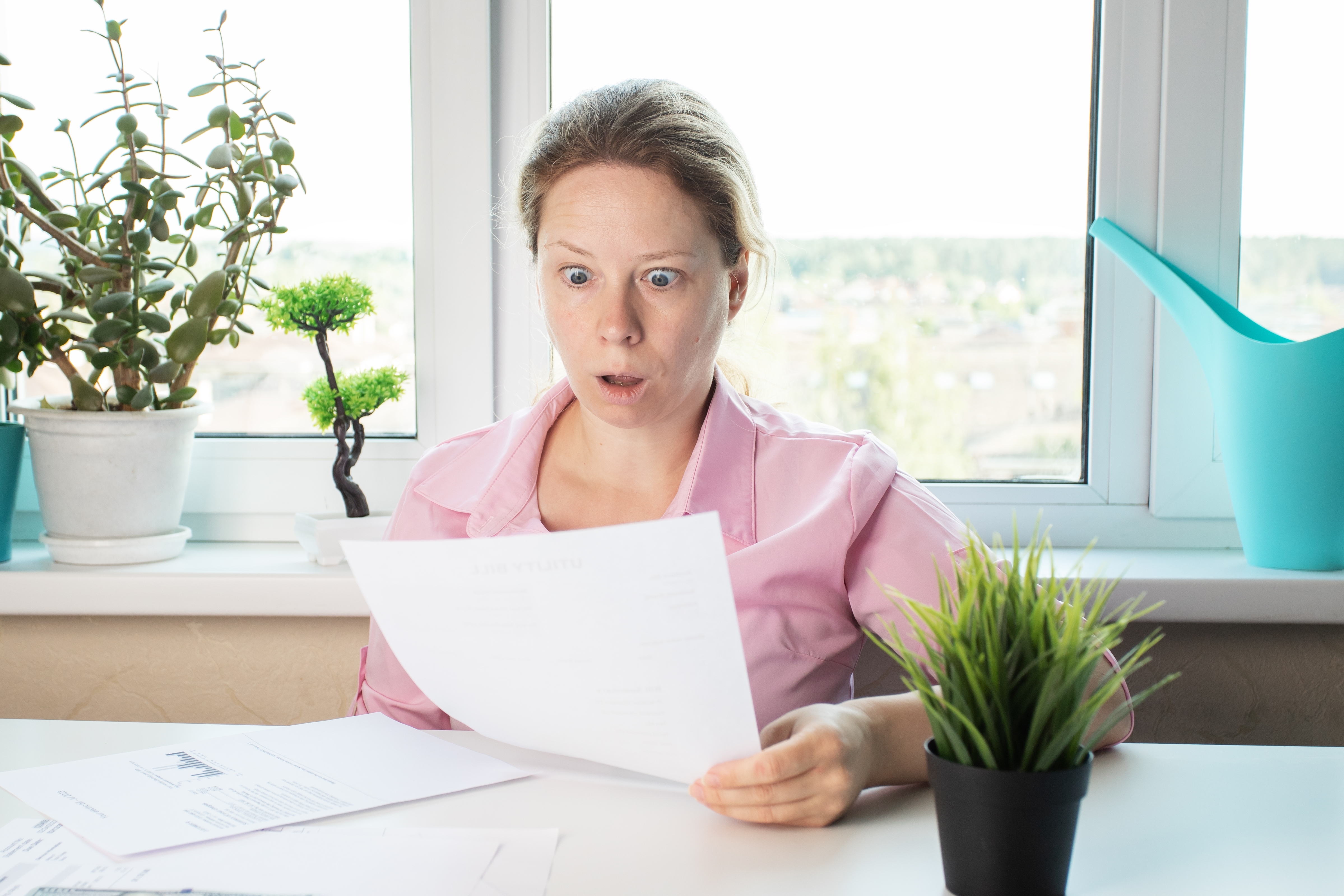 A shocked woman reading a letter | Source: Shutterstock