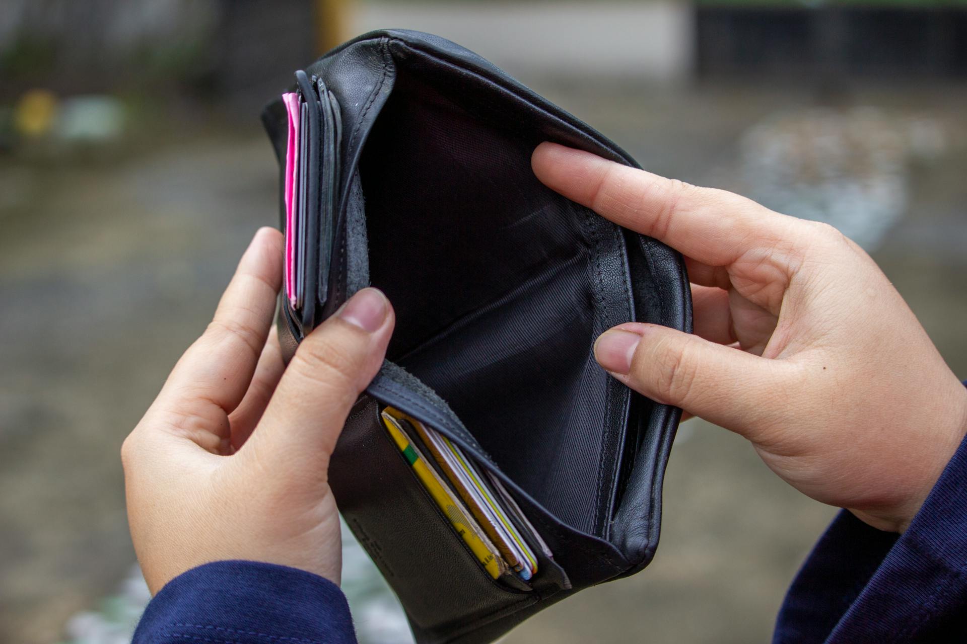 A person holding their empty wallet | Source: Pexels