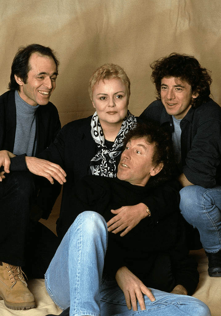 Les Enfoirés, composés du chanteur français Patrick Bruel, de l'humoriste Muriel Robin, des chanteurs et auteurs Jean-Jacques Goldman et Alain Souchon, soutiennent l'association humanitaire "Les restaurants du coeur" fondée par le comique Michel Colucci aka Coluche. | Photo : Getty Images