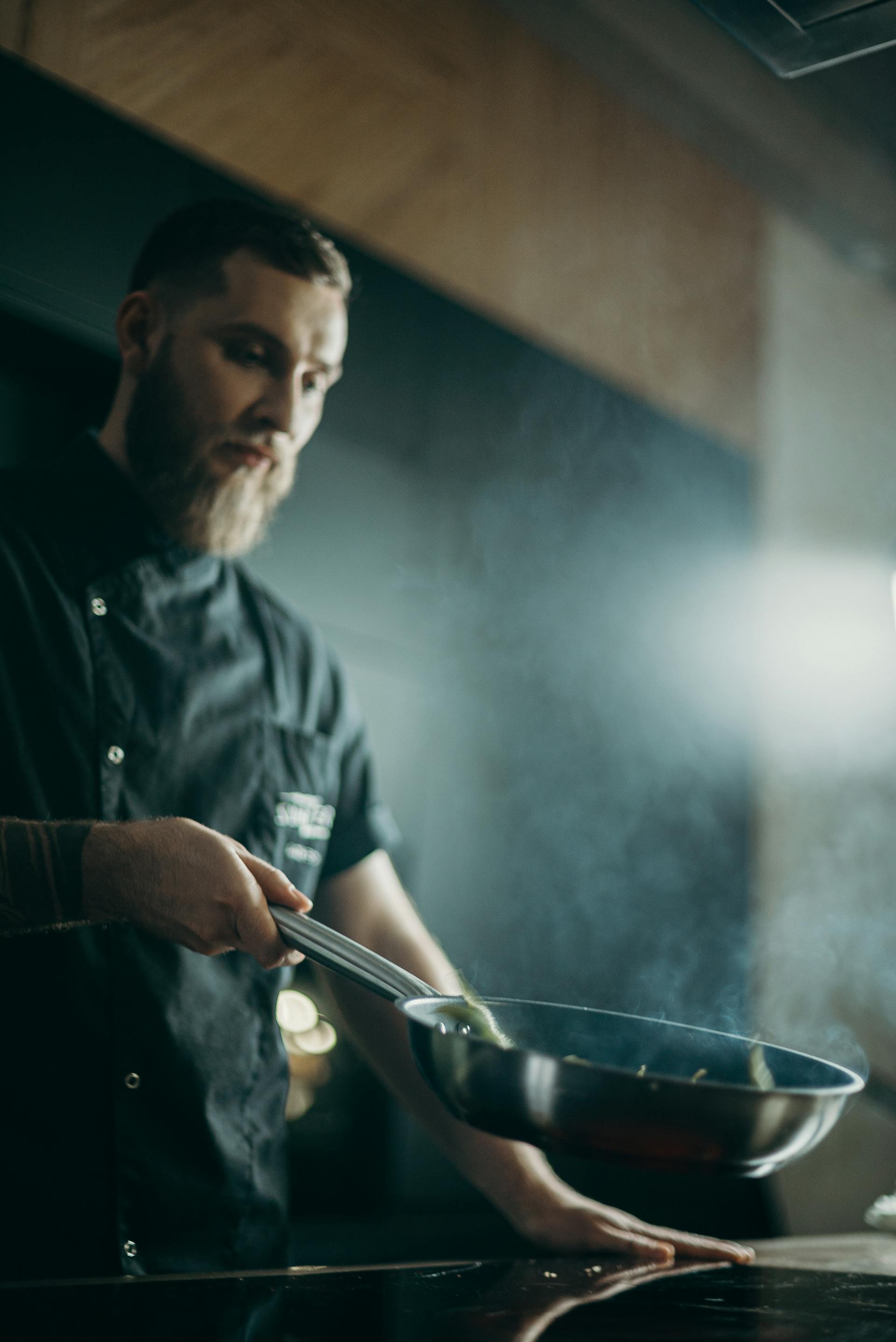 A man in the kitchen holding a pan | Source: Pexels