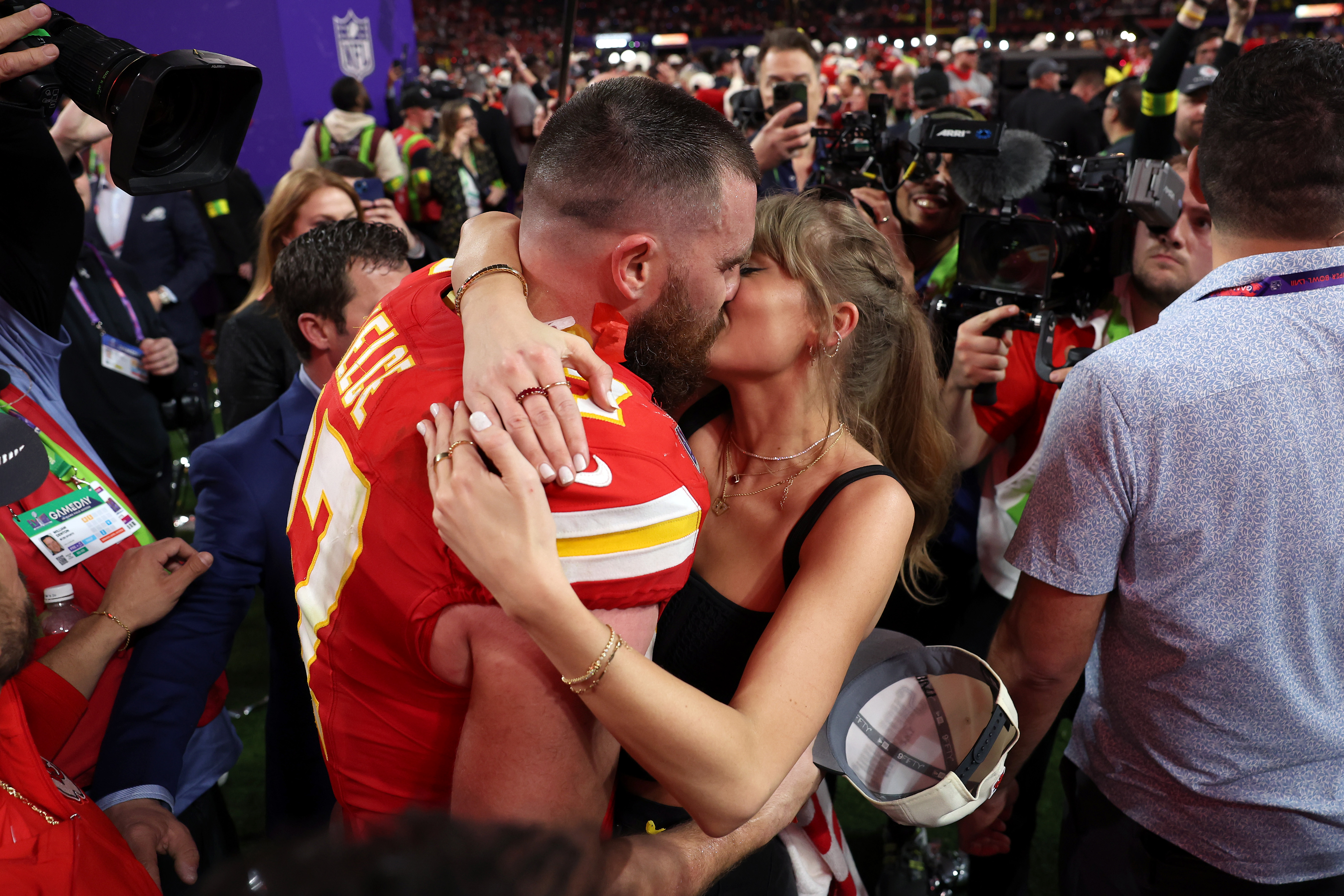 Travis Kelce #87 of the Kansas City Chiefs kisses Taylor Swift on the field after the team's 25-22 overtime victory against the San Francisco 49ers in Super Bowl LVIII at Allegiant Stadium on February 11, 2024, in Las Vegas, Nevada.