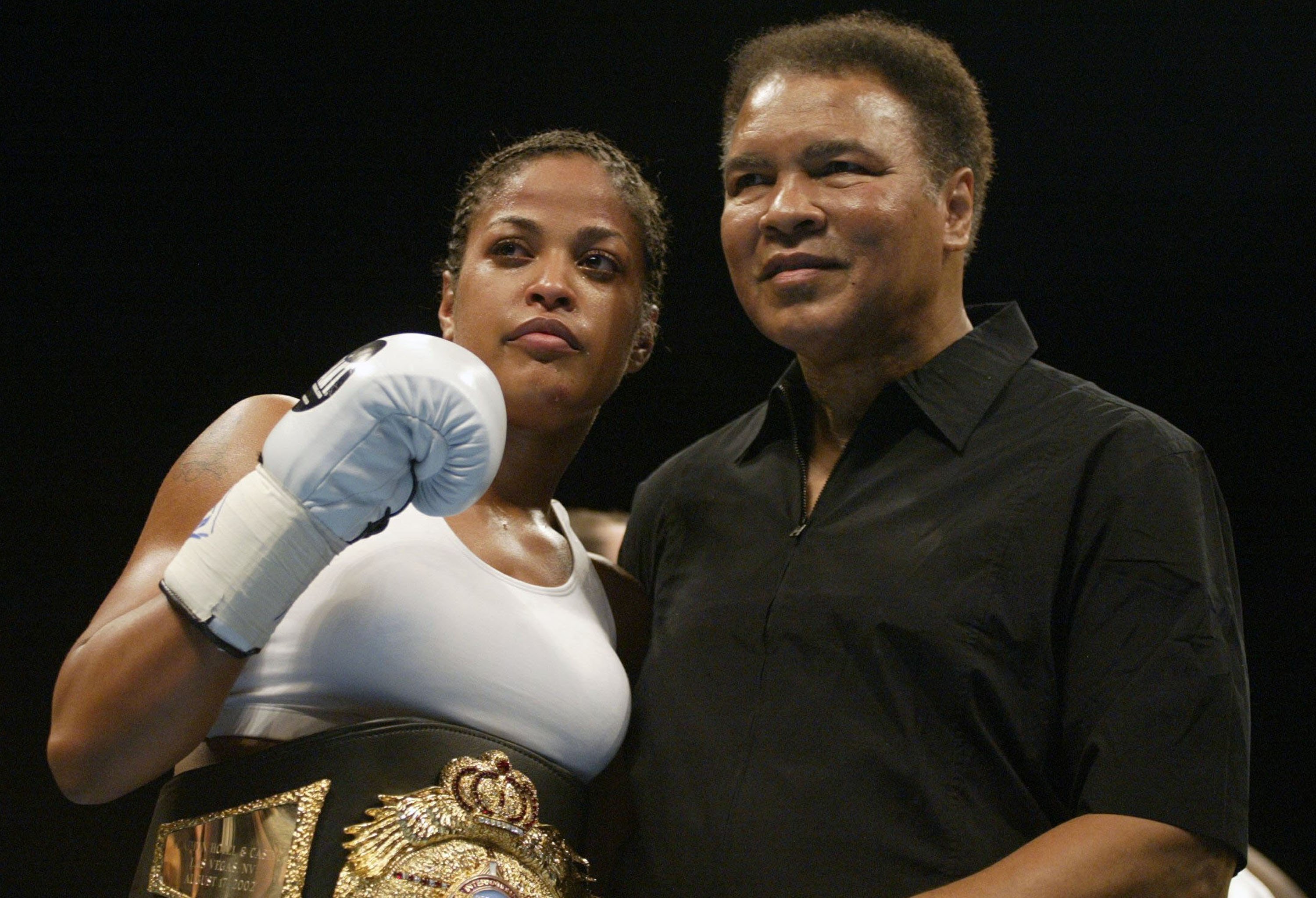 Laila Ali poses with her father, former boxer, Muhammad Ali, after defeating Suzy Taylor after two rounds at the Aladdin Casino on August 17, 2002 | Photo: Getty Images