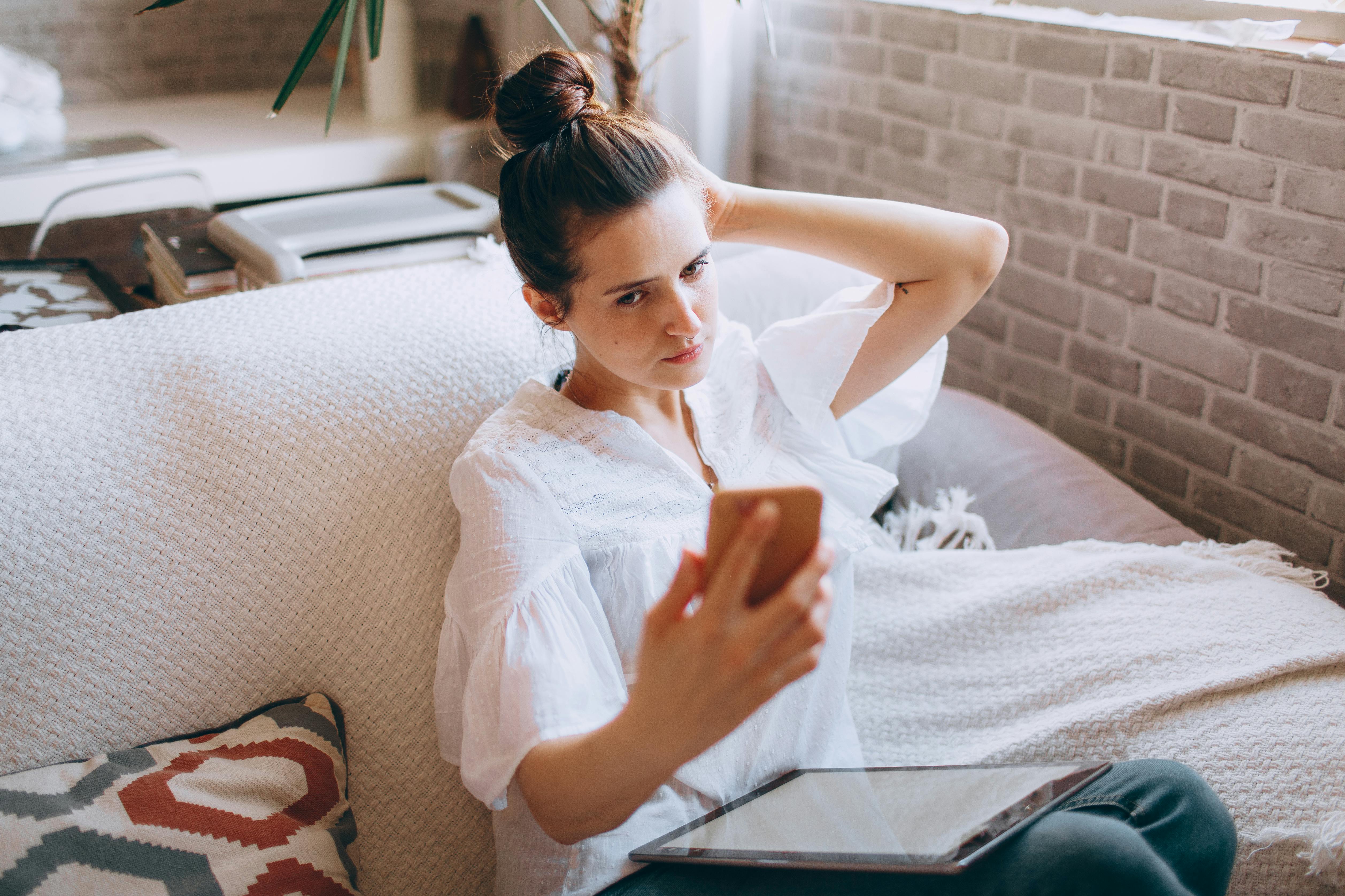 An annoyed woman looking at her phone | Source: Pexels