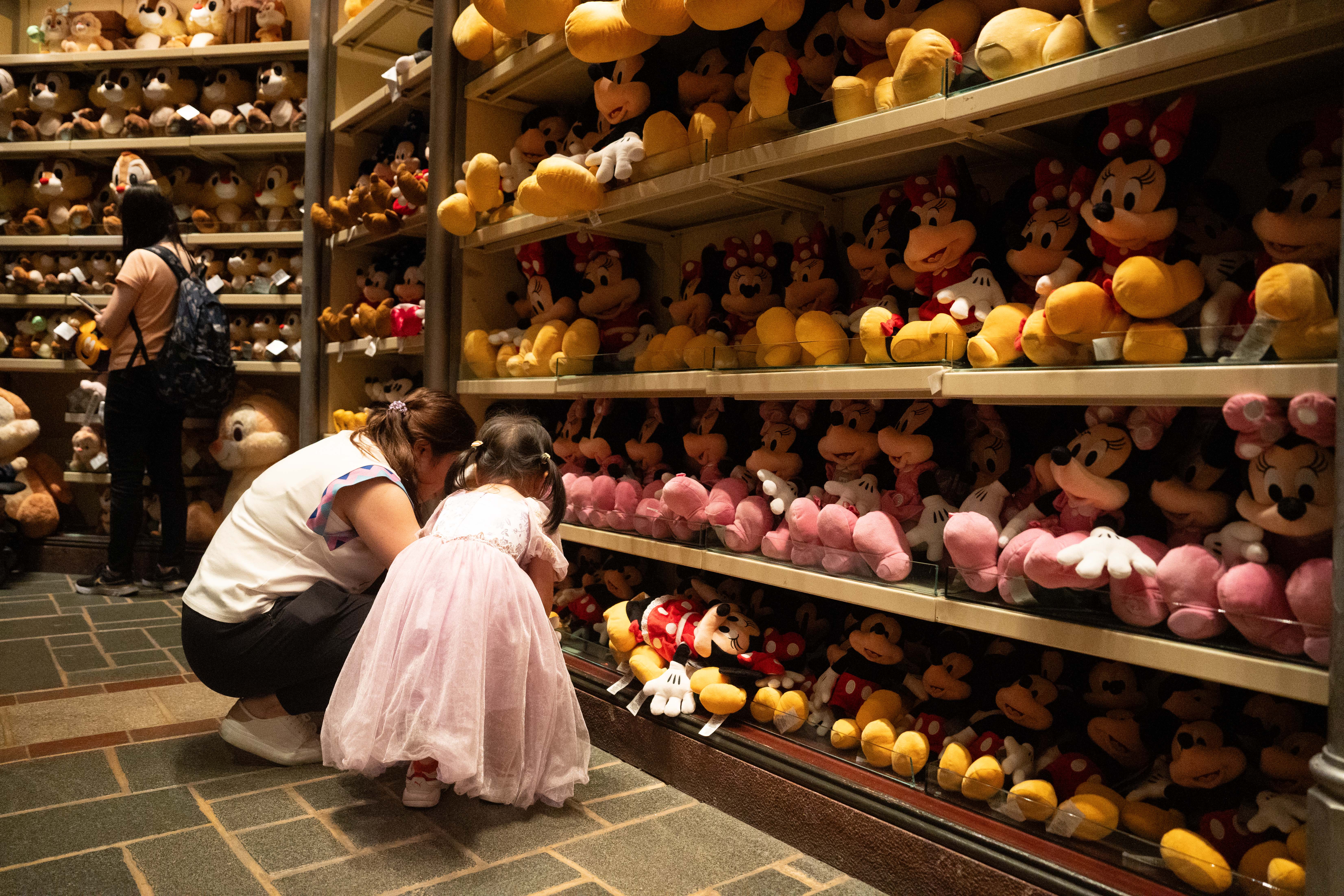 A girl and an older woman at Disney shop with stuffed toys | Source: Getty Images