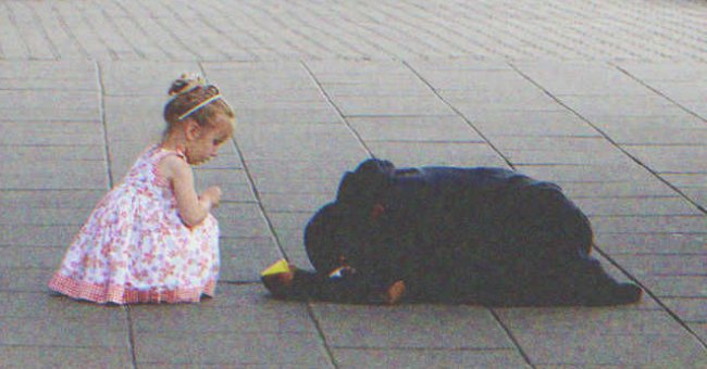 Una niña pequeña se acerca aun mendigo en la calle. | Foto: Shutterstock