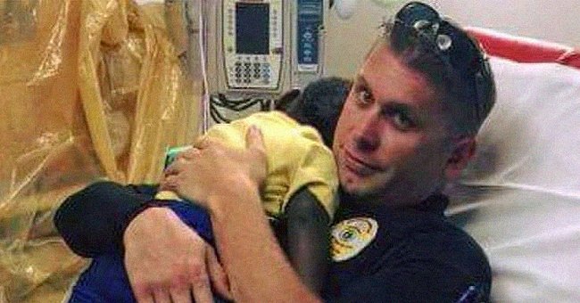 Ein Foto von einem Polizisten, der ein Baby tröstet, geht viral | Quelle: Facebook/JohnTesh