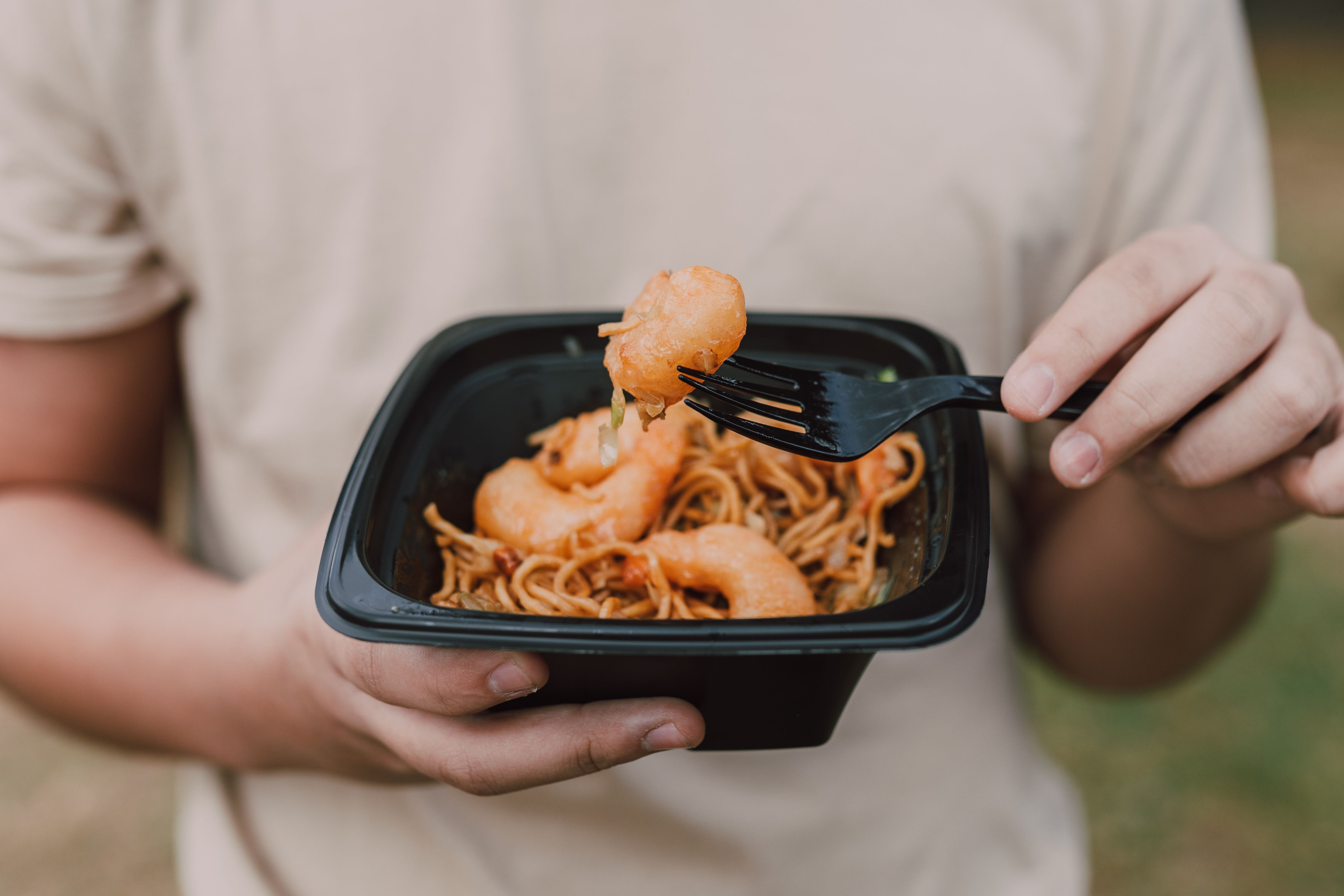 A person consuming food from a plastic container | Source: Pexels